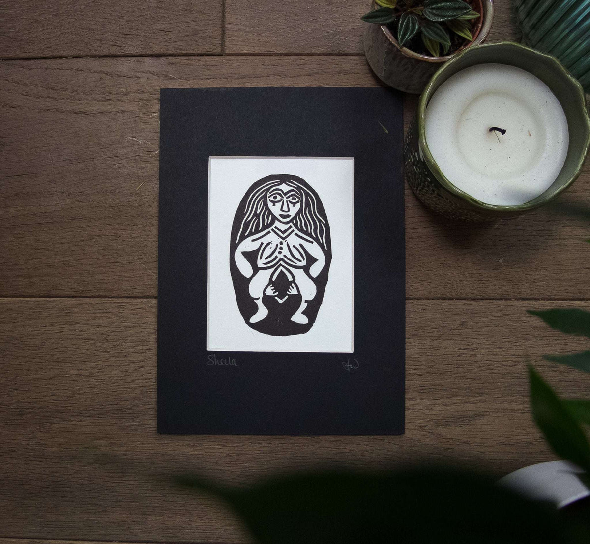 Celtic Mythology linocut print showing a black and white long-haired goddess holding a small figure