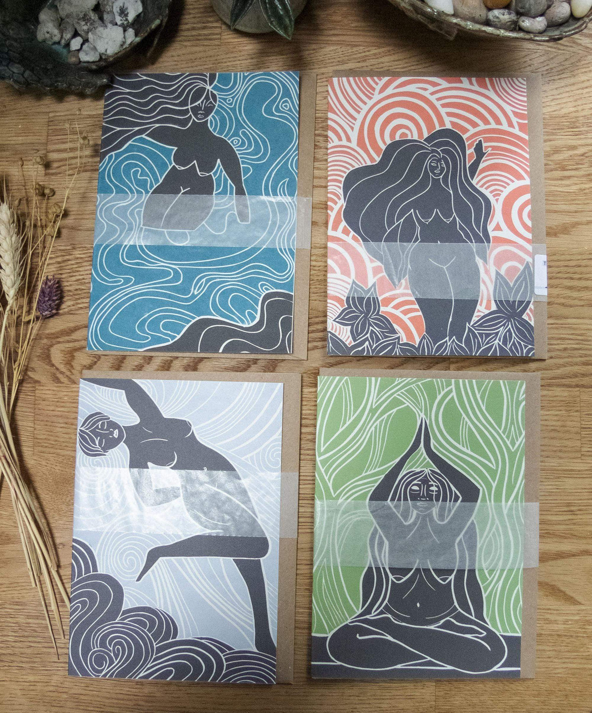 The Zodiac Collection linocut artwork featuring four goddess figures on blue, coral, pale blue and green patterned prints