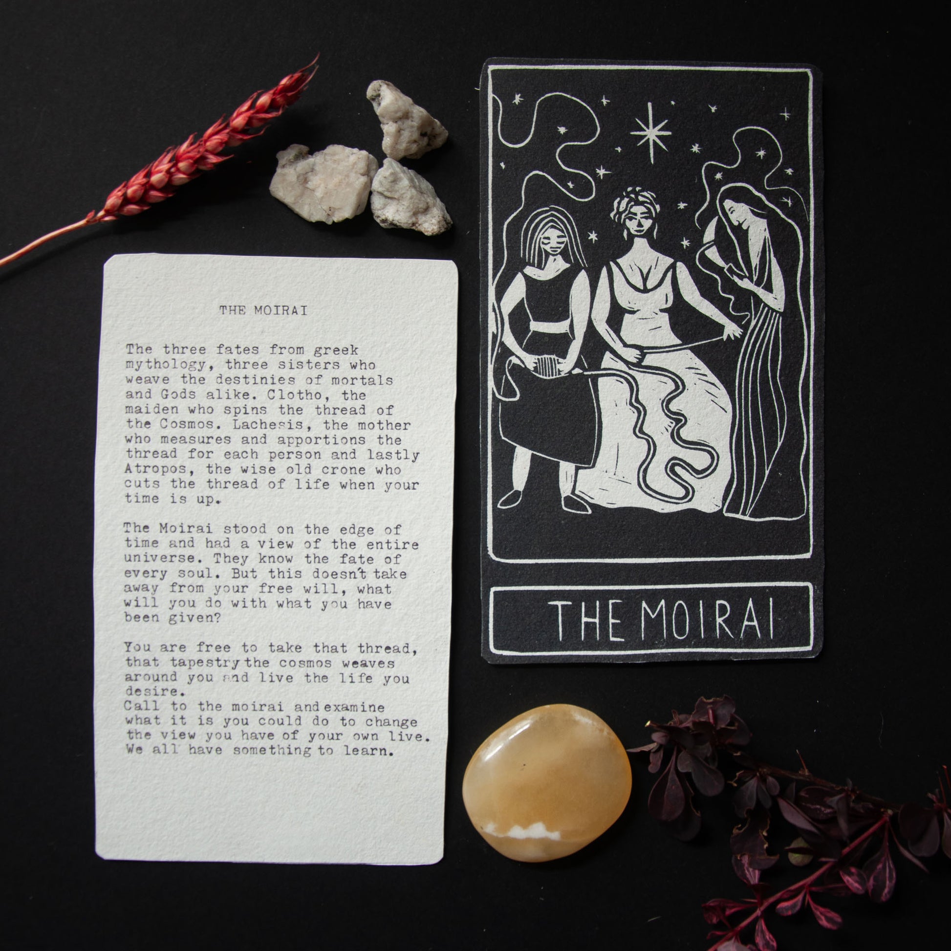 Tarot card titled 'The Moirai' with on a dark background