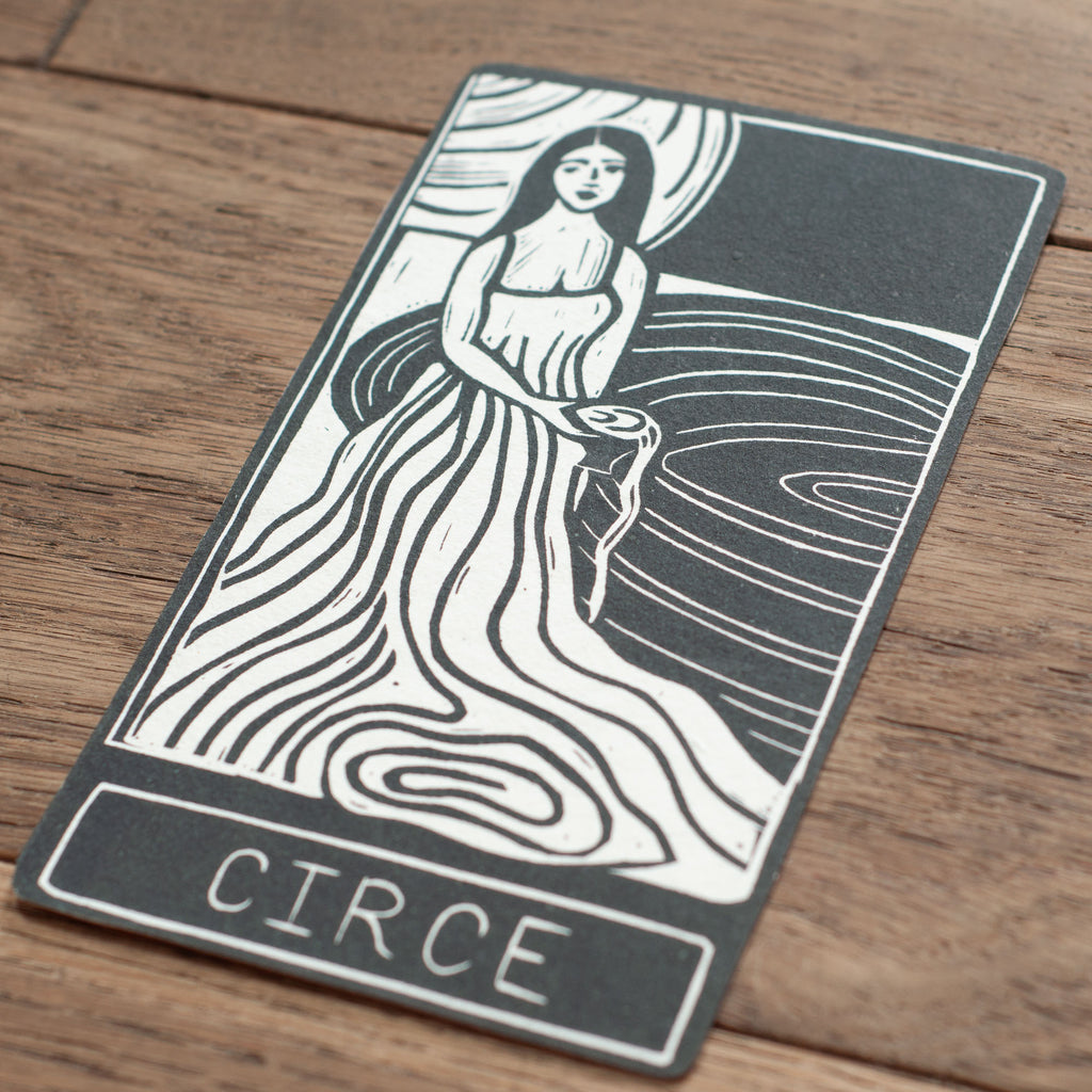 Tarot card featuring a woman with 'Circe' at the bottom on a wooden surface