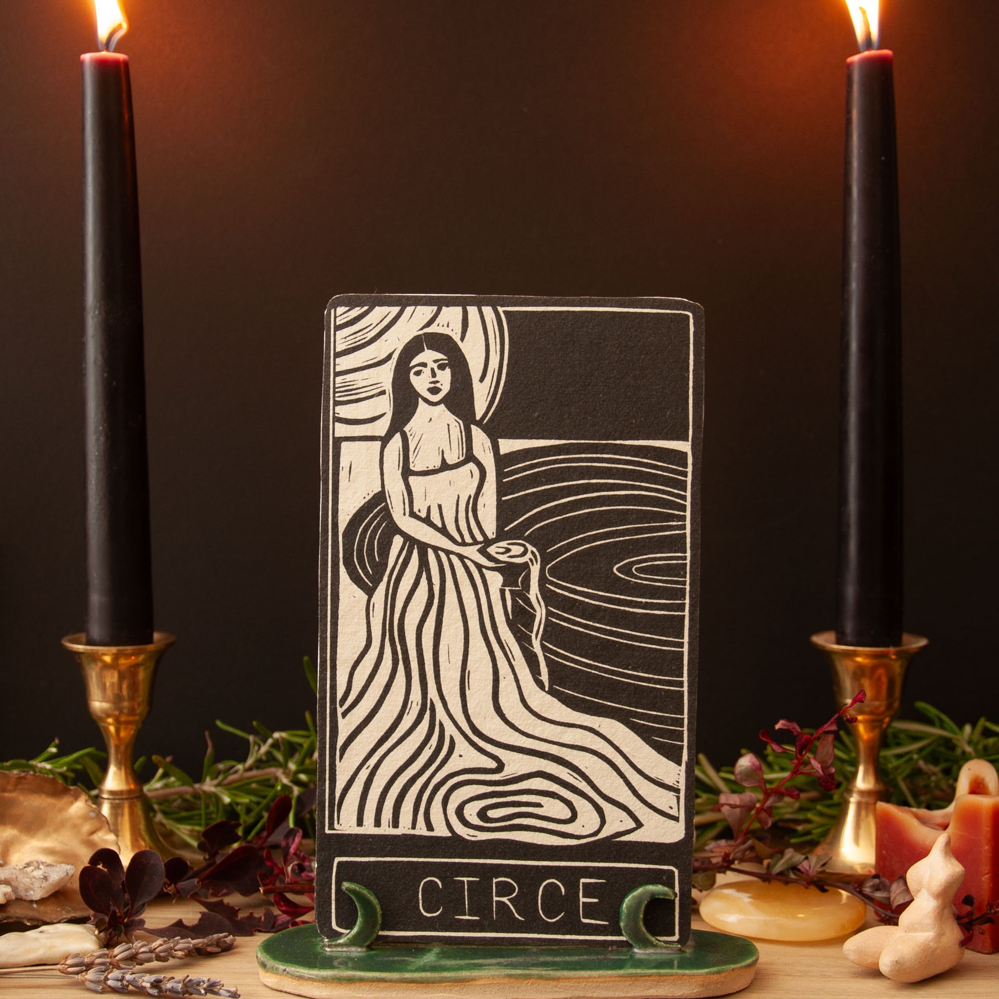 Tarot card featuring a woman labeled 'Circe' with candles and herbs on a dark background