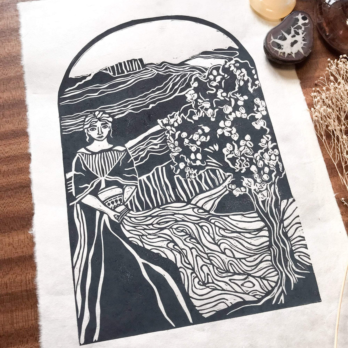 Linocut print, ANAHIT | ARMENIAN GODDESS, in deep blue-grey ink with a flowing-robed figure beside a flowering tree