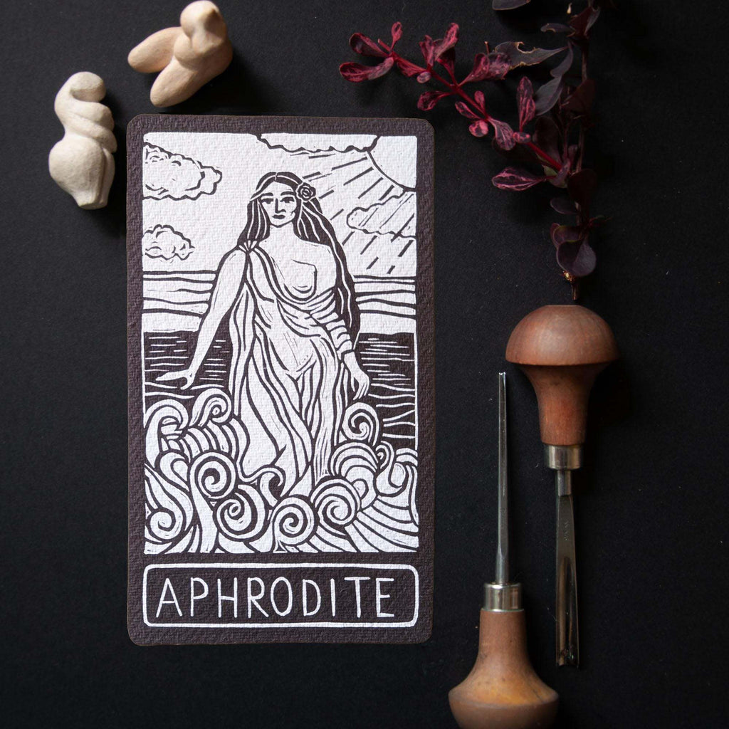 APHRODITE ALTAR CARD in dark cotton rag, featuring a black linocut-style illustration of Aphrodite amid waves
