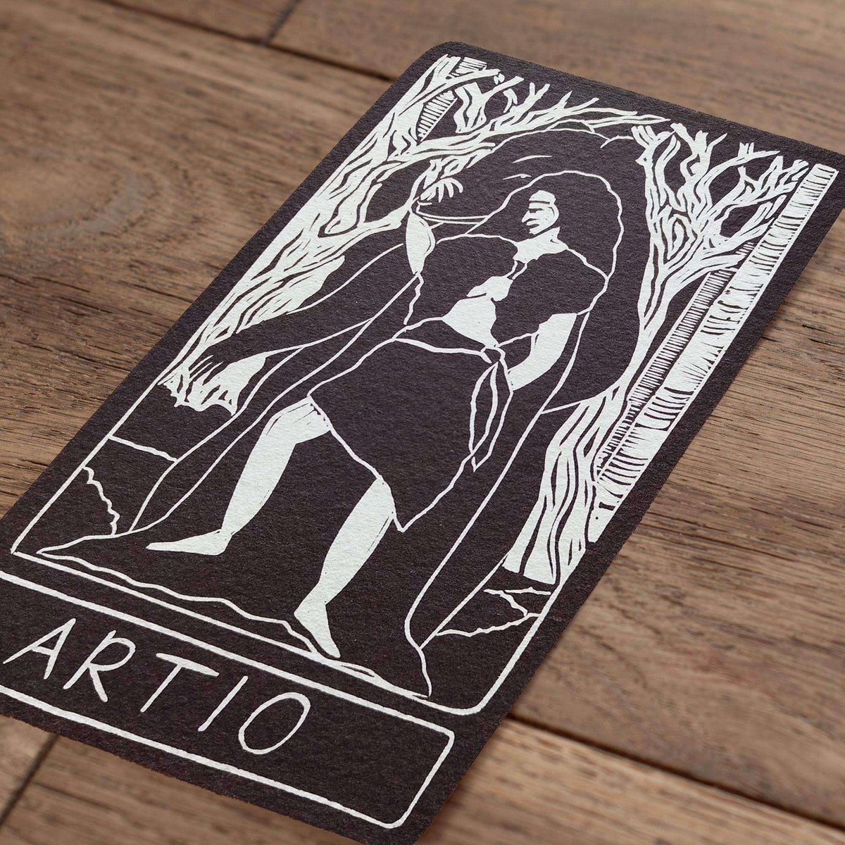 ARTIO ALTAR CARD in black and white, showing a linocut-style seated figure framed by trees with ARTIO lettering