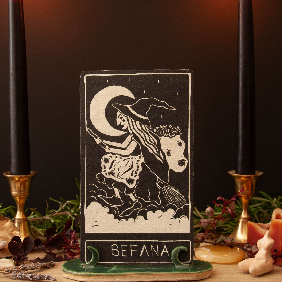 BEFANA ORACLE CARD, cream linocut-style witch and crescent moon on a dark brown card with a green base.