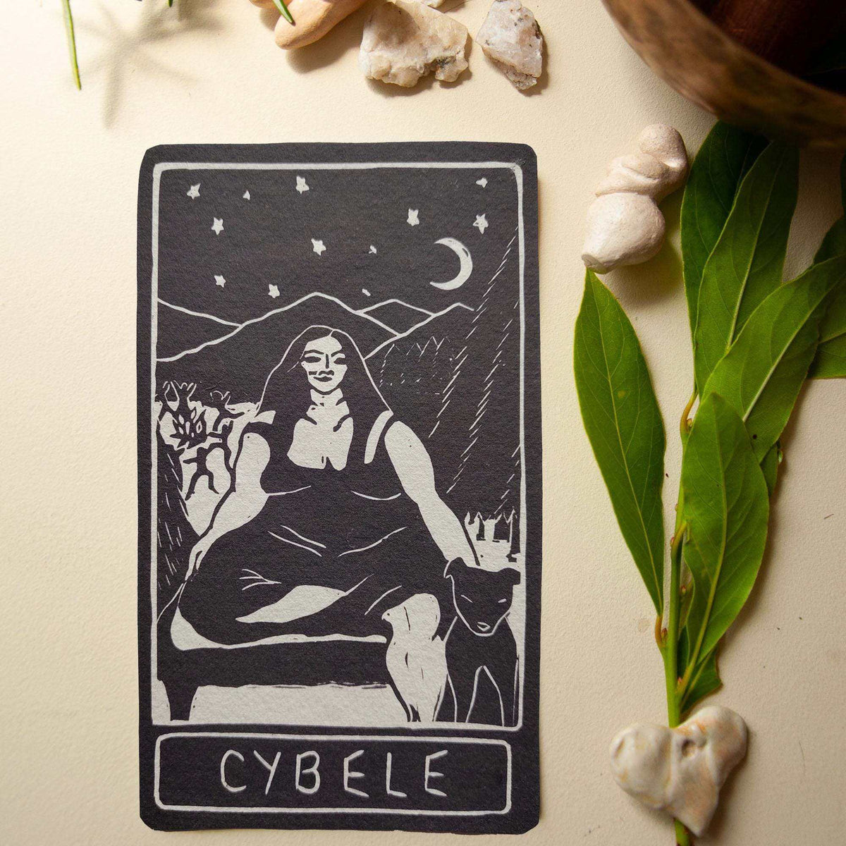 CYBELE ALTAR CARD in black and white, featuring a seated goddess, crescent moon, stars and animal linocut design