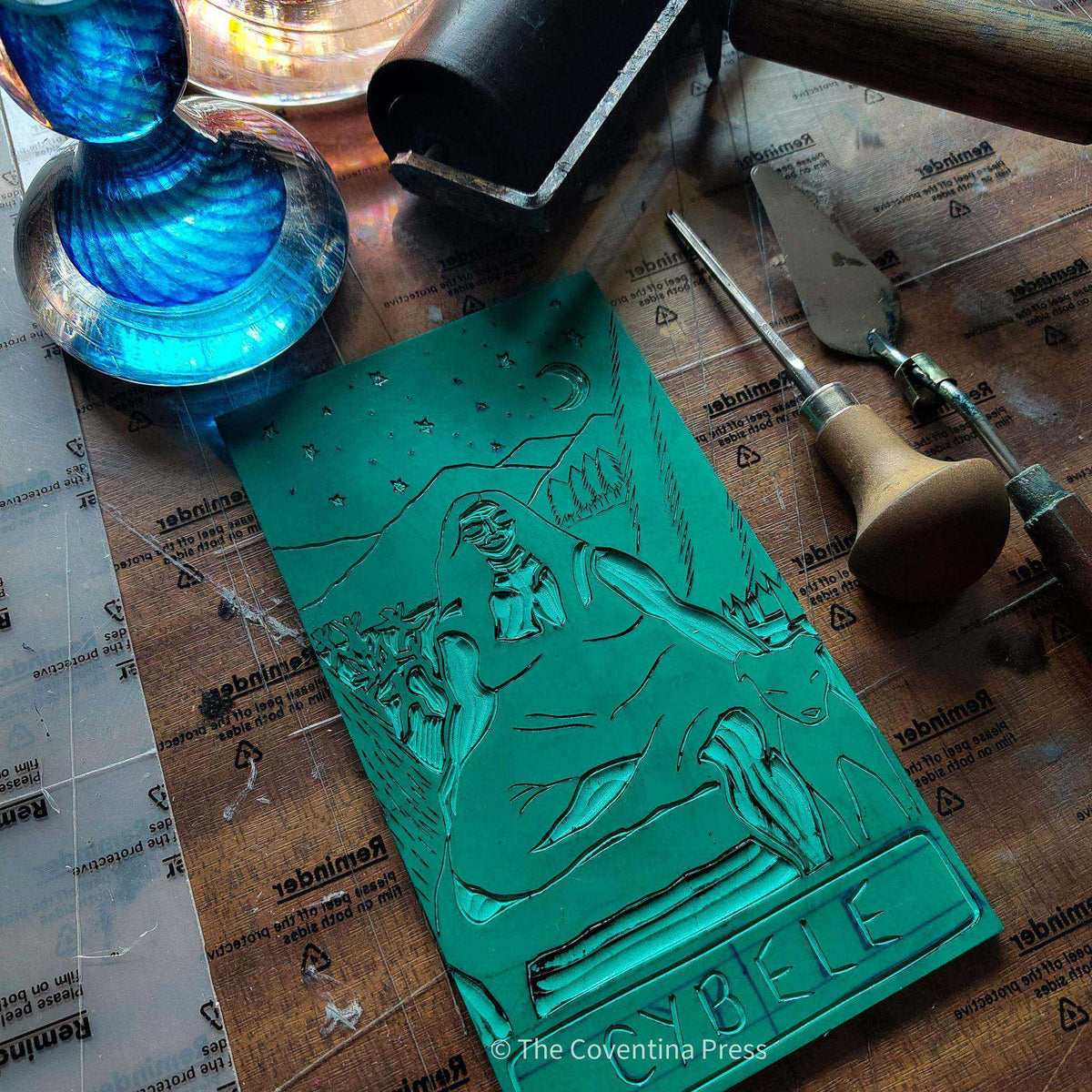 CYBELE ALTAR CARD featuring a teal linocut block with a carved seated goddess, animals, mountains and lettering