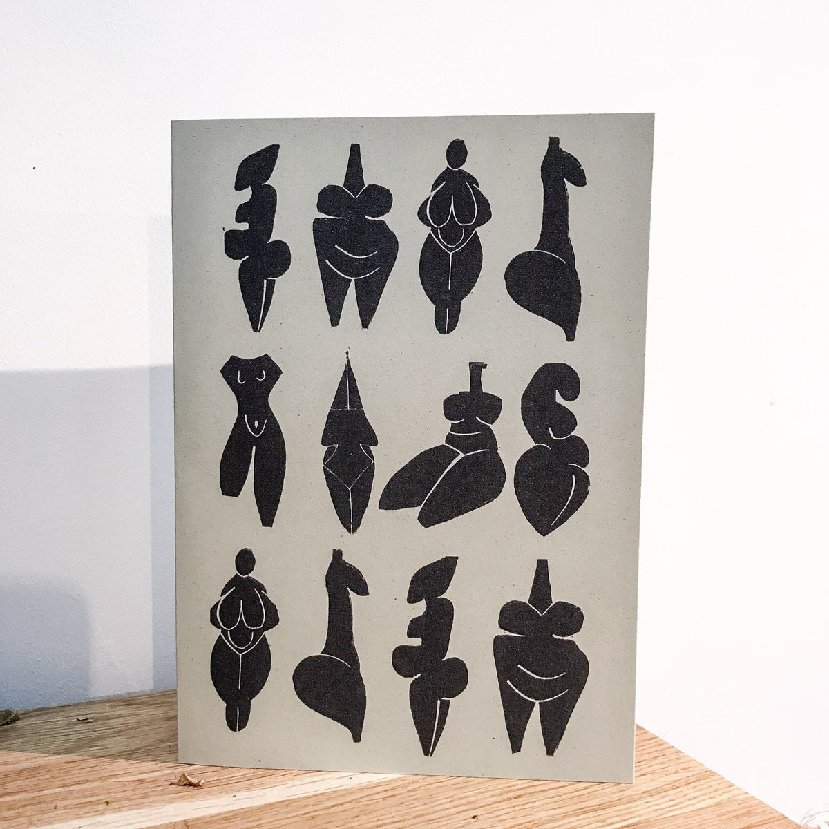 DANCING GODDESSES greeting card in natural cream cardstock, featuring black linocut prints of stylized prehistoric female figures