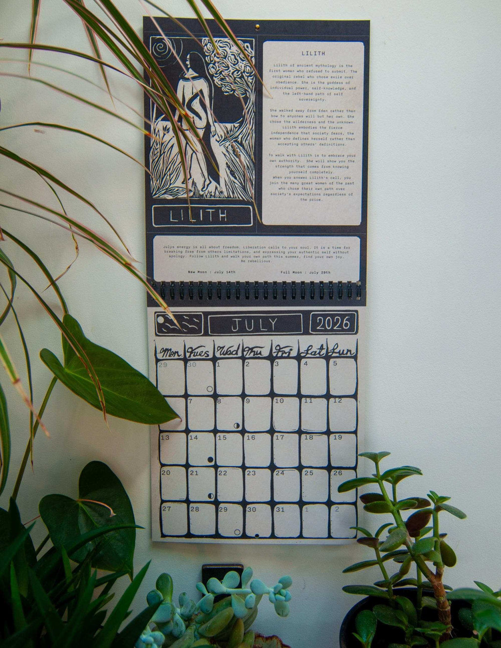 Dark Goddess Calendar 2027 with black and cream Lilith linocut artwork, mythology text, and a spiral-bound July 2026 grid