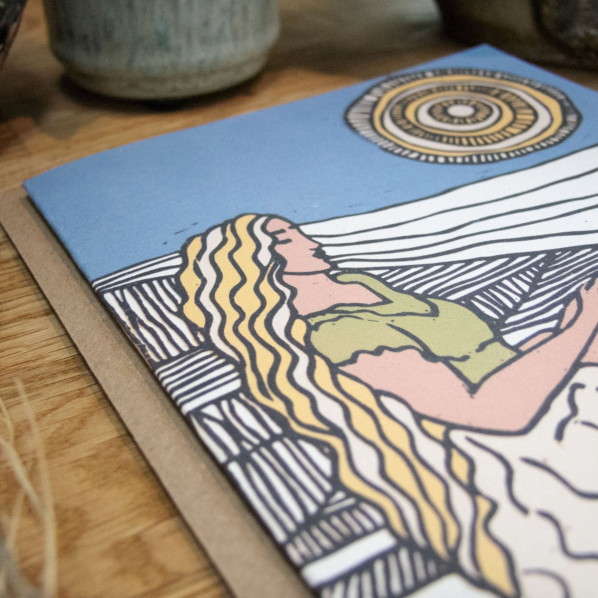 DEMETER Greeting card with a colourful linocut goddess, flowing blonde hair, green clothing and a patterned sun