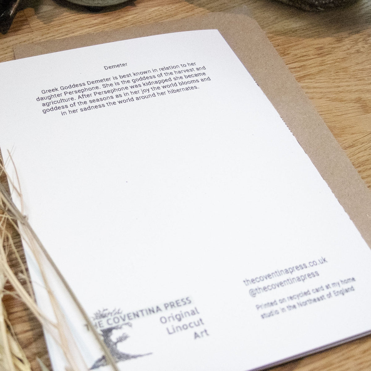 DEMETER Greeting card with a white cardstock back, black printed text and a small linocut maker’s mark.