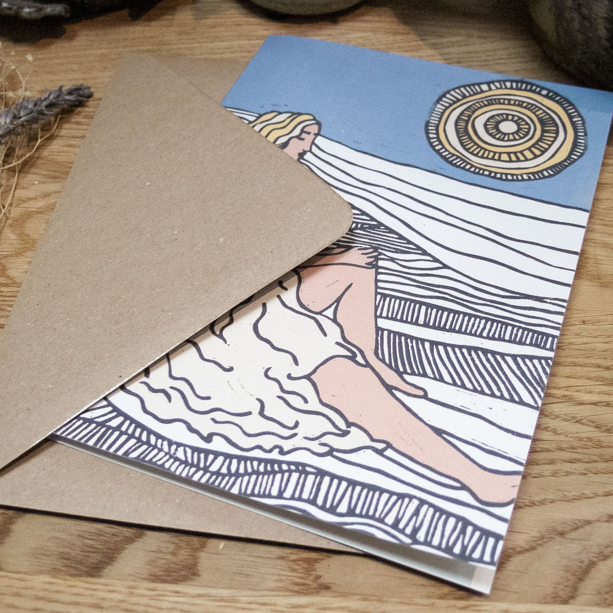 DEMETER Greeting card in recycled natural cardstock, featuring a blue and cream linocut goddess design and kraft envelope.