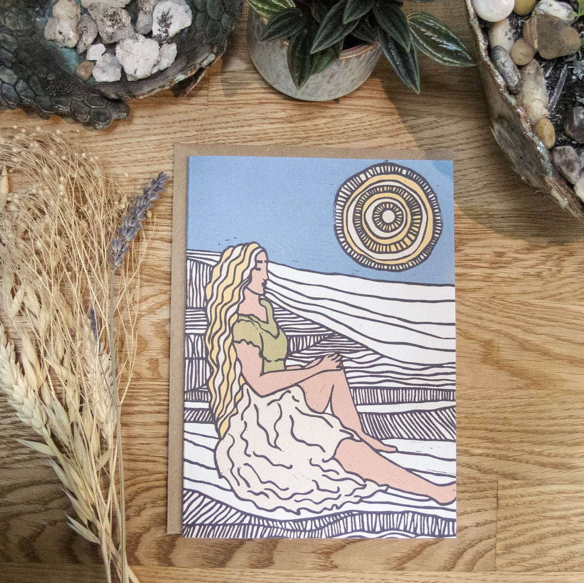 DEMETER Greeting card with a multicolour linocut goddess in a flowing white dress beneath a patterned sun