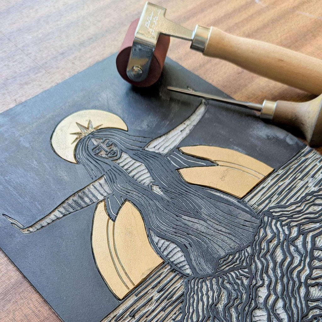 Divine Sophia Art linocut block showing a dark-haired goddess in a flowing robe, with pale crescent shapes and carved lines