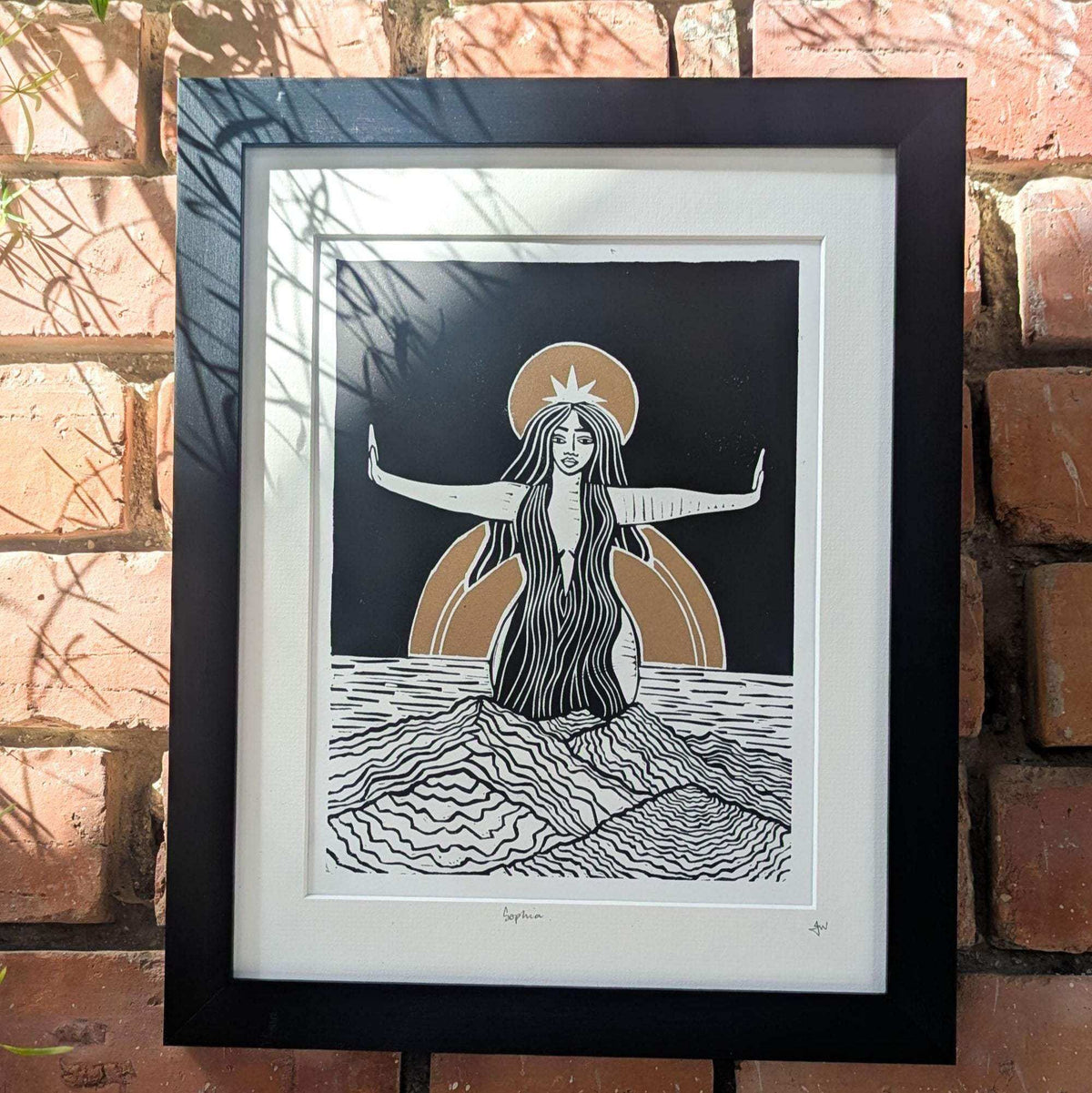 Divine Sophia Art linocut print showing a long-haired goddess with outstretched arms, black, white and gold details