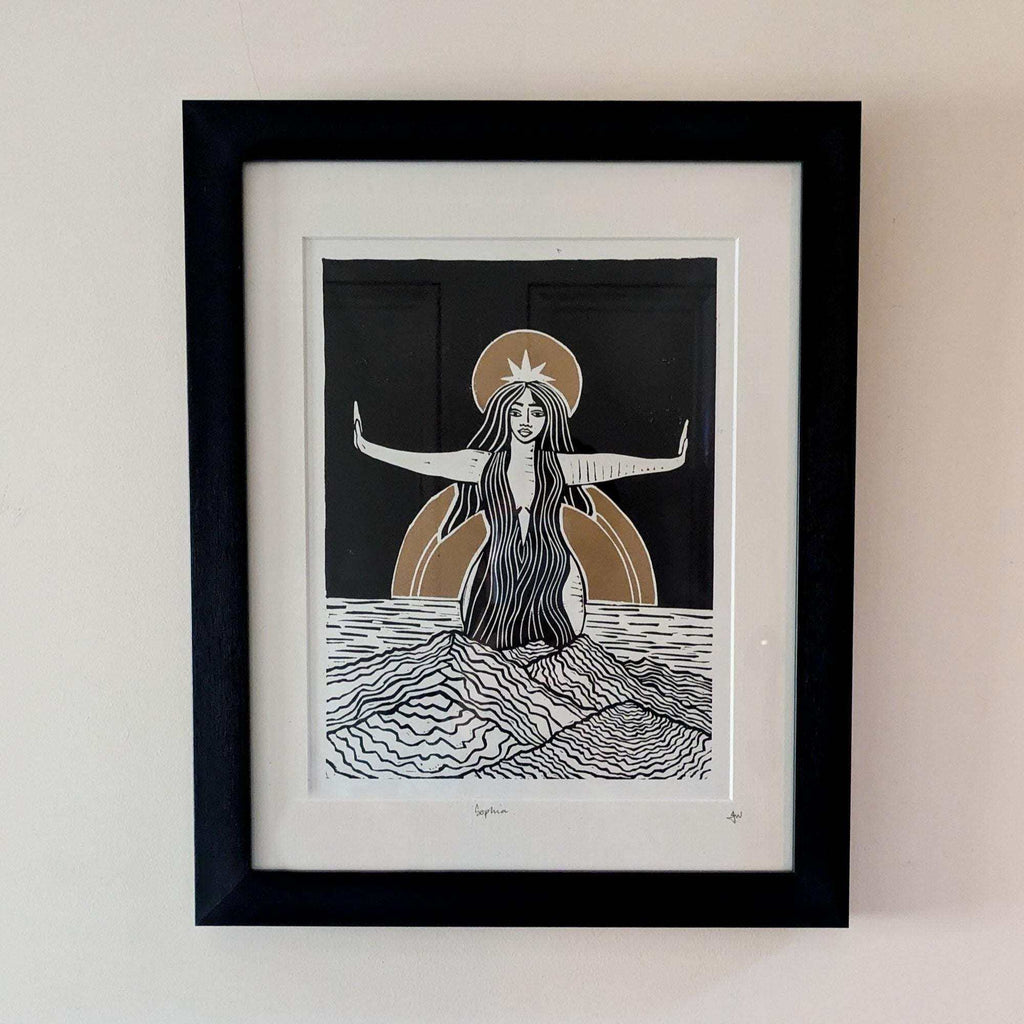Divine Sophia Art linocut print of a long-haired goddess with outstretched arms, black, white and ochre on paper