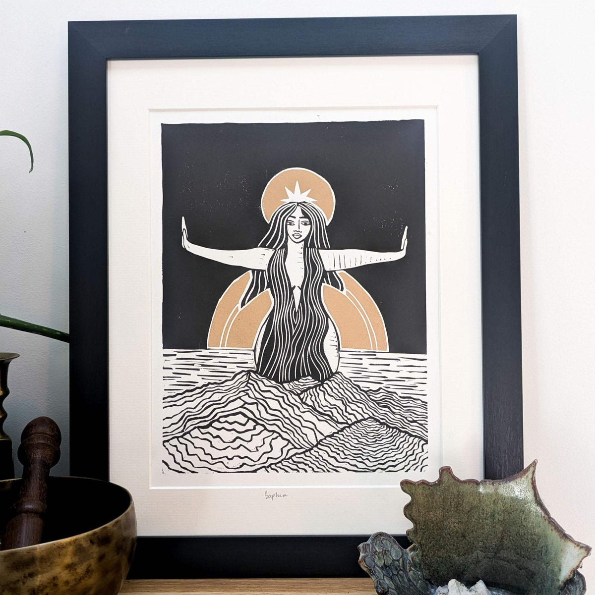 Divine Sophia Art linocut print in black and white with warm ochre sun, showing a woman with outstretched arms above waves