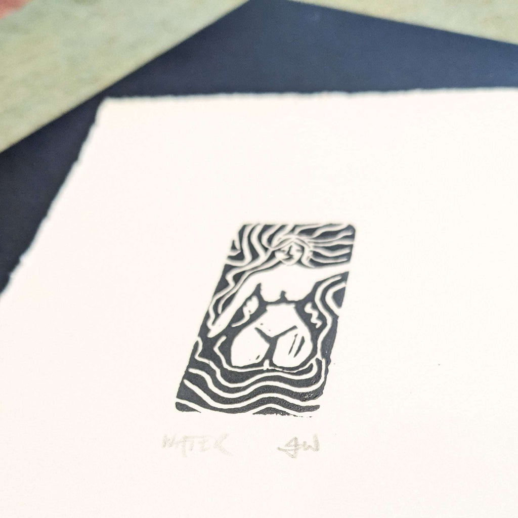 ELEMENTAL GODDESS miniature black linocut print on cream paper, depicting a seated figure surrounded by flowing lines