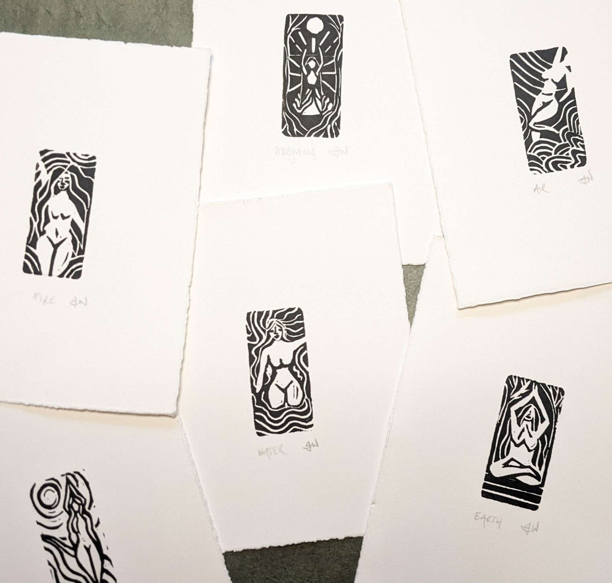 ELEMENTAL GODDESS miniature linocut prints in black ink, featuring white goddess figures and intricate elemental patterns on cream paper