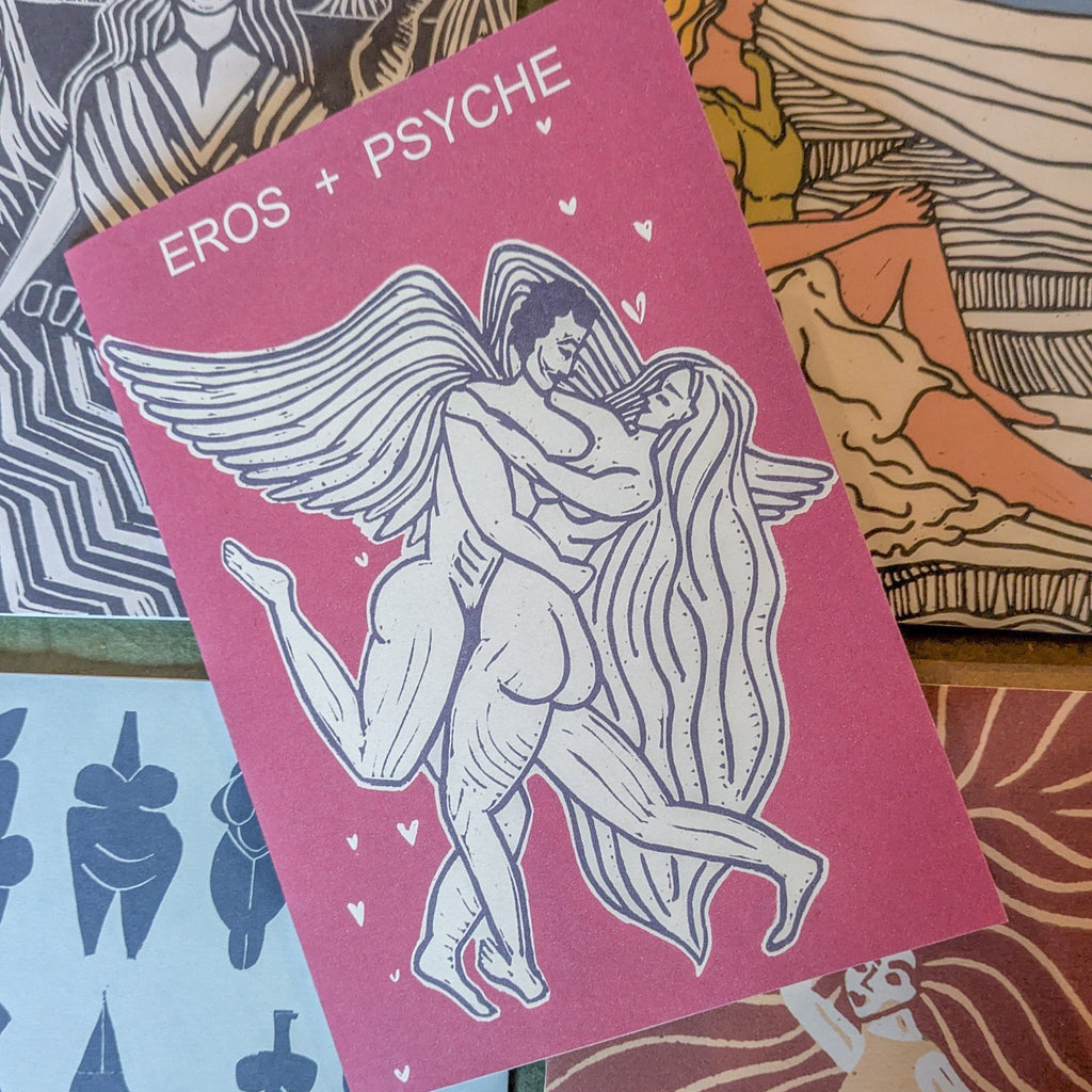 EROS AND PSYCHE Greeting card in magenta cardstock, featuring a black-and-white linocut of winged lovers embracing with small hearts.