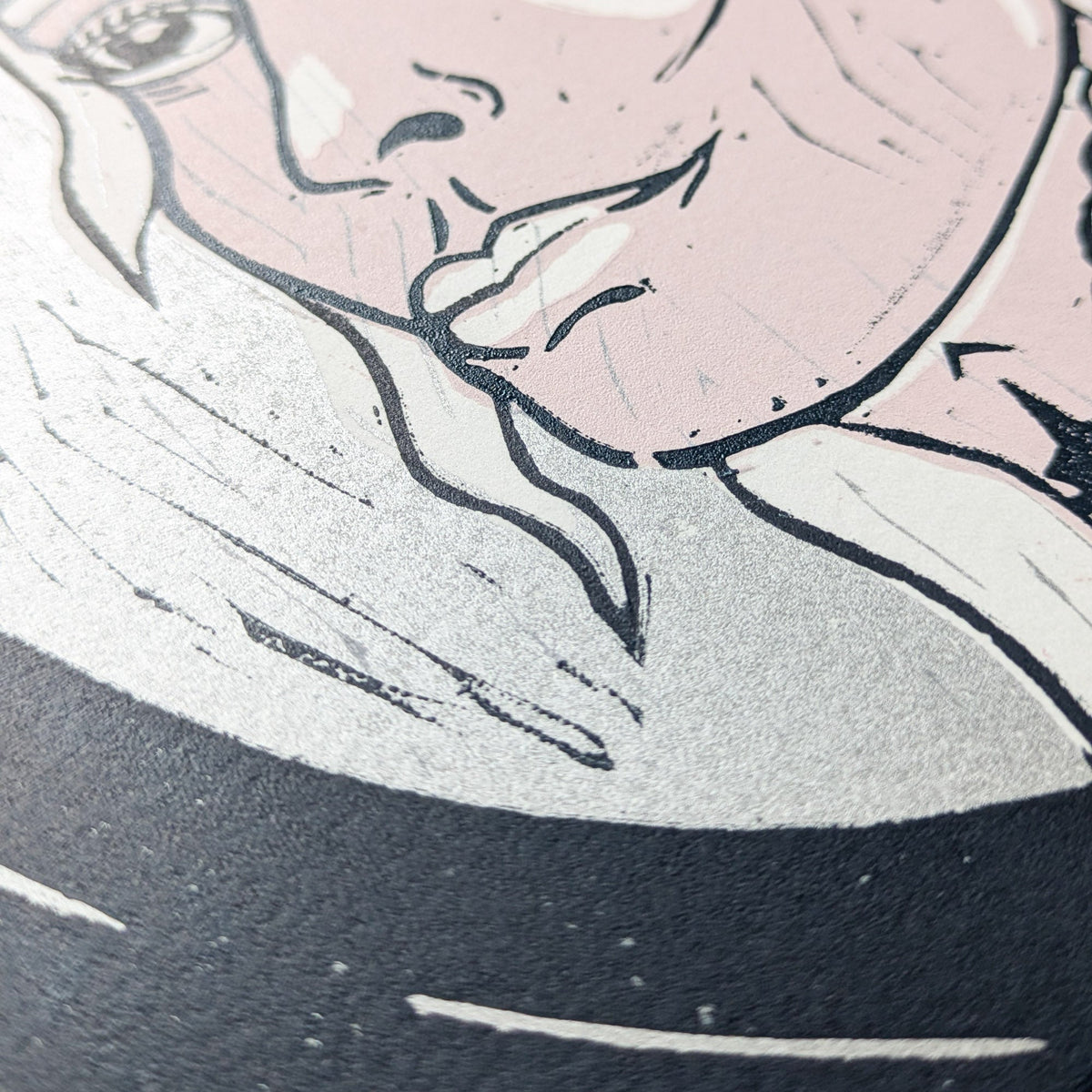 FRIGG | NORSE LOVE GODDESS linocut print showing a close-up of a pale face in black and silver ink