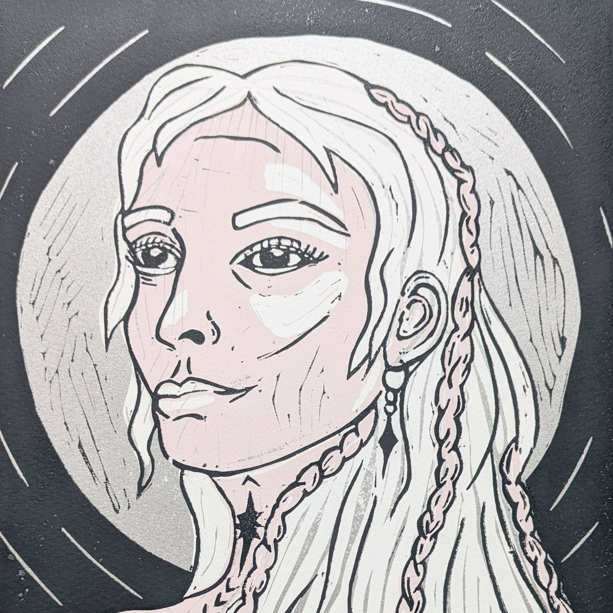 FRIGG | NORSE LOVE GODDESS linocut print depicting a woman with long braided hair in black, white and pale pink