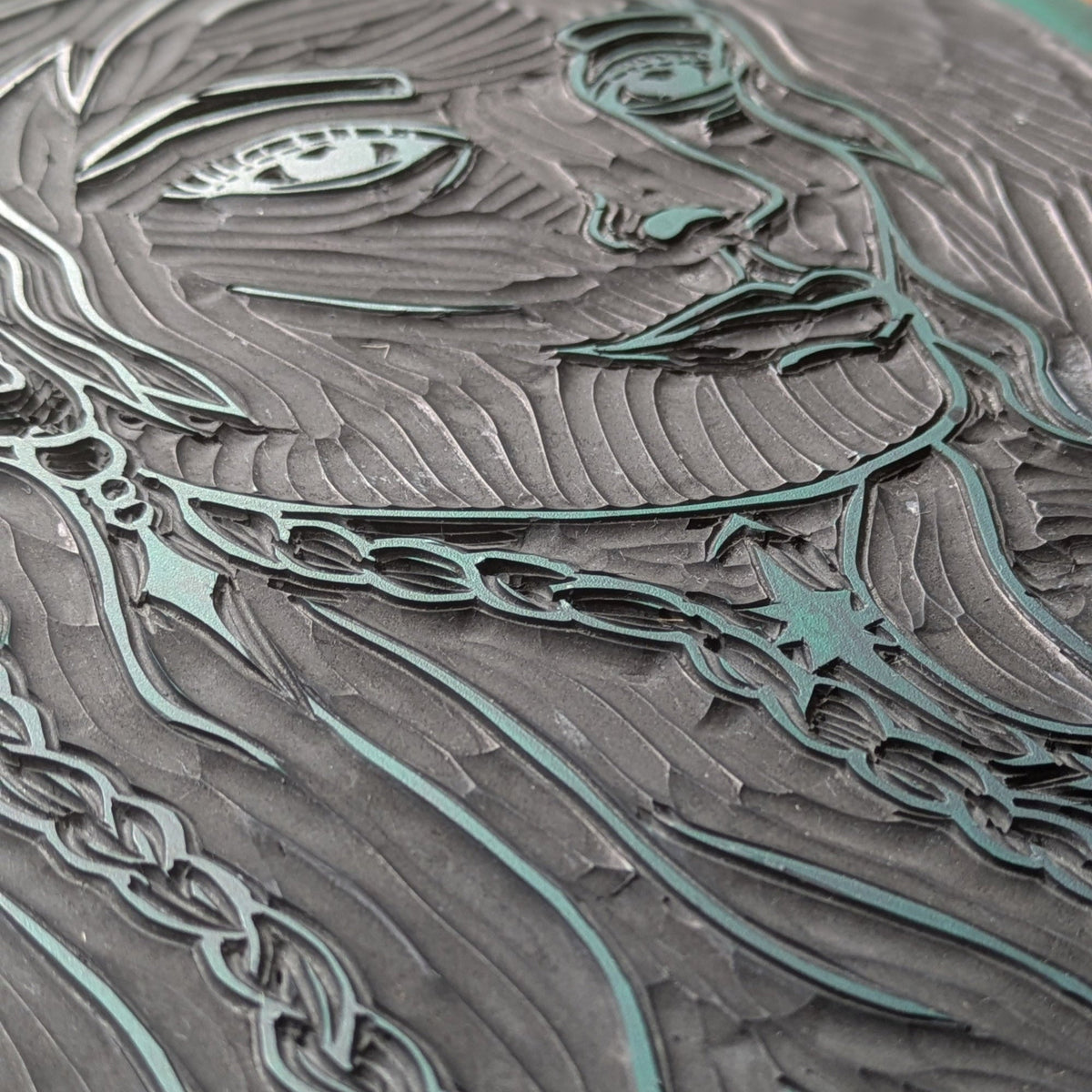 FRIGG | NORSE LOVE GODDESS linocut print showing a carved female profile with flowing hair and teal-grey ink