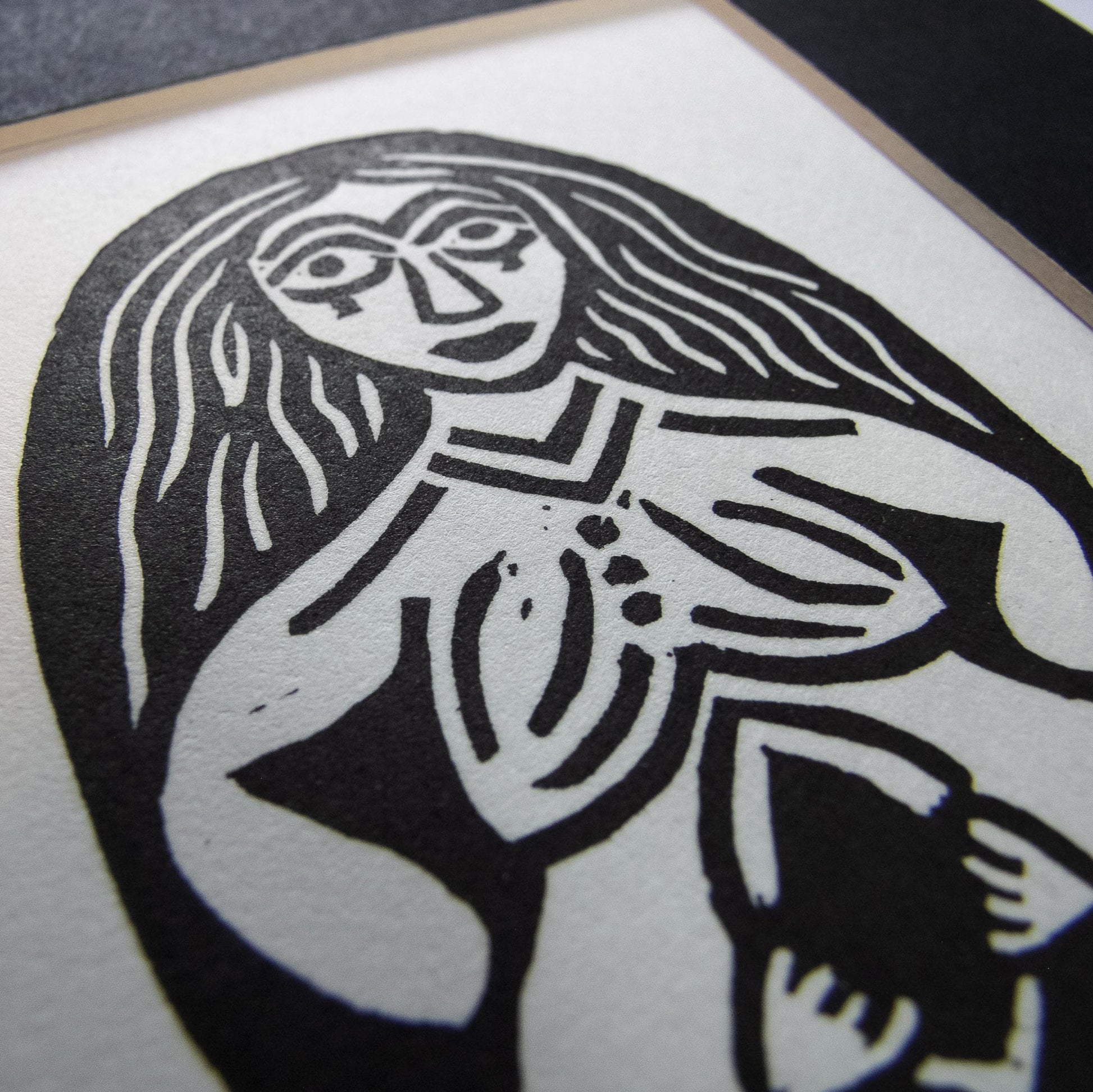 close up shot of the sheela na gig print with a black mount