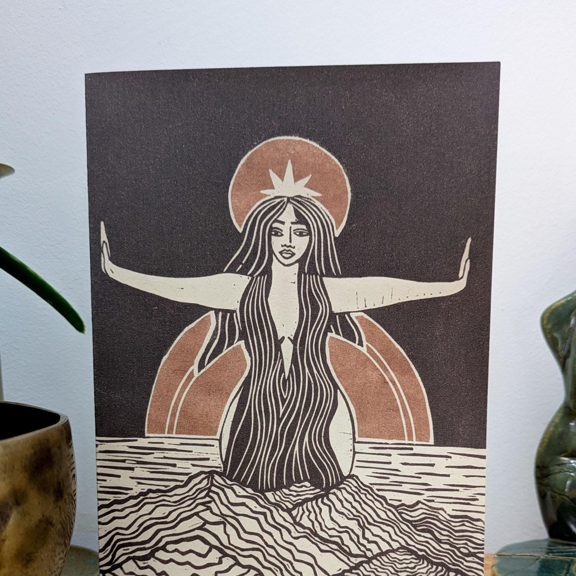 greeting card of divine sophia linocut print in black and dusky gold sun behind her