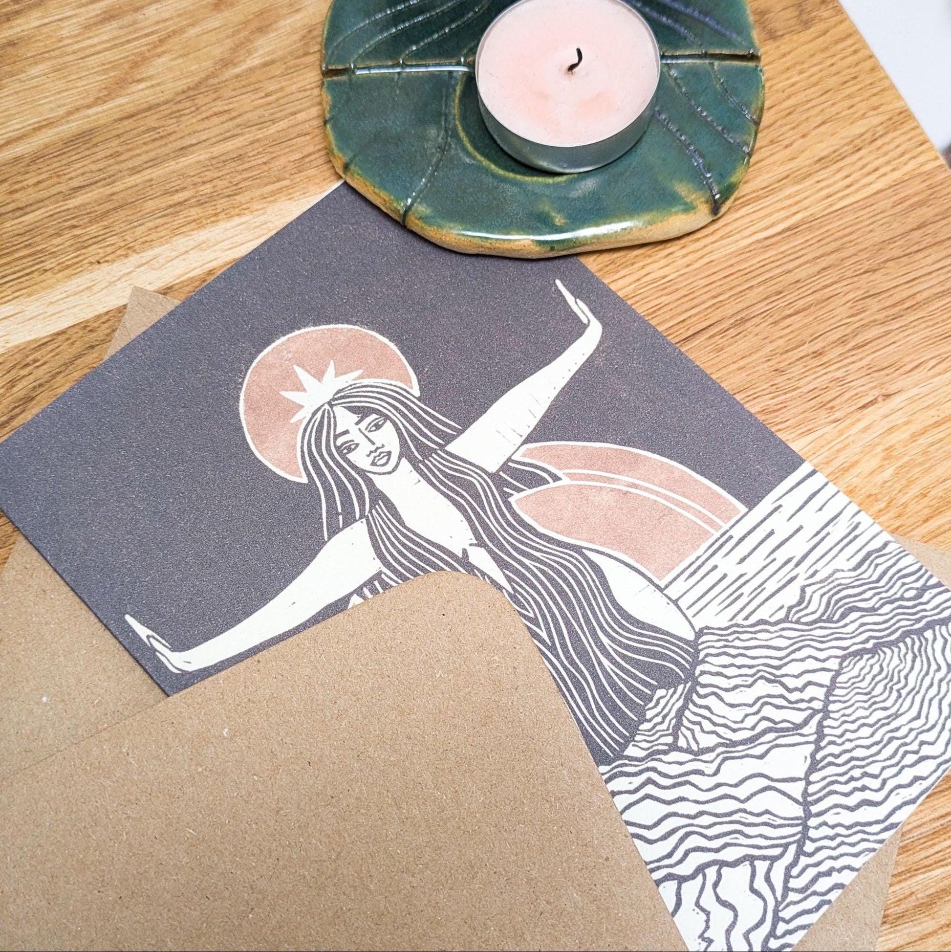 greeting card of divine sophia linocut print in black and dusky gold sun behind her