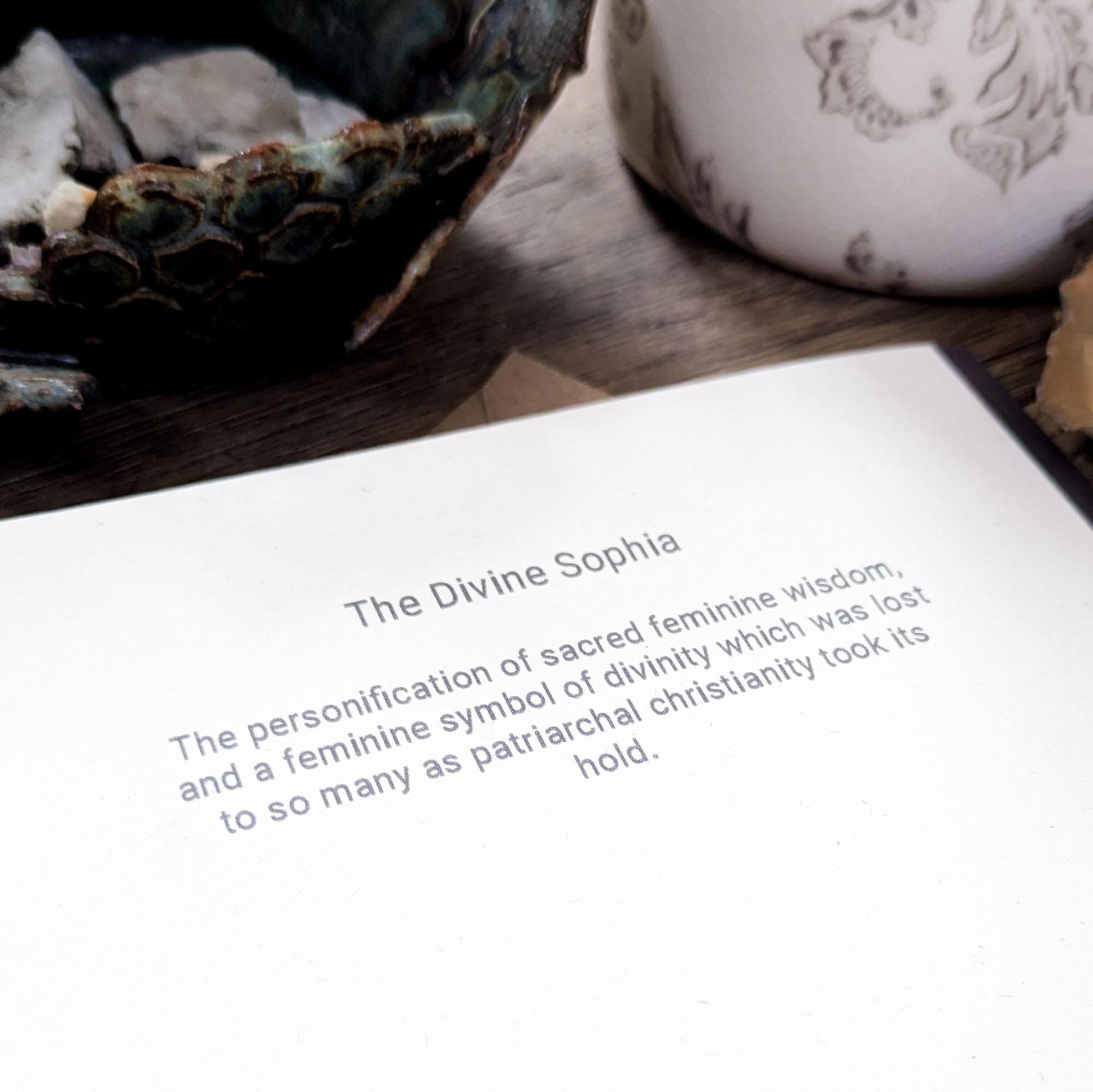 greeting card of divine sophia linocut print in black and dusky gold sun behind her