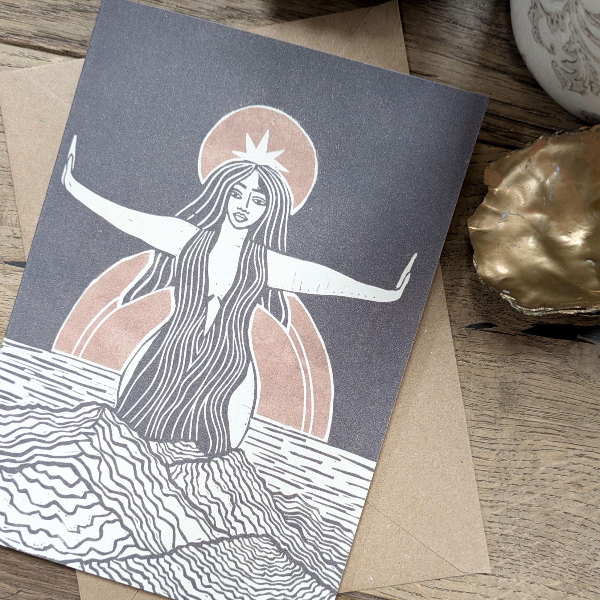 greeting card of divine sophia linocut print in black and dusky gold sun behind her