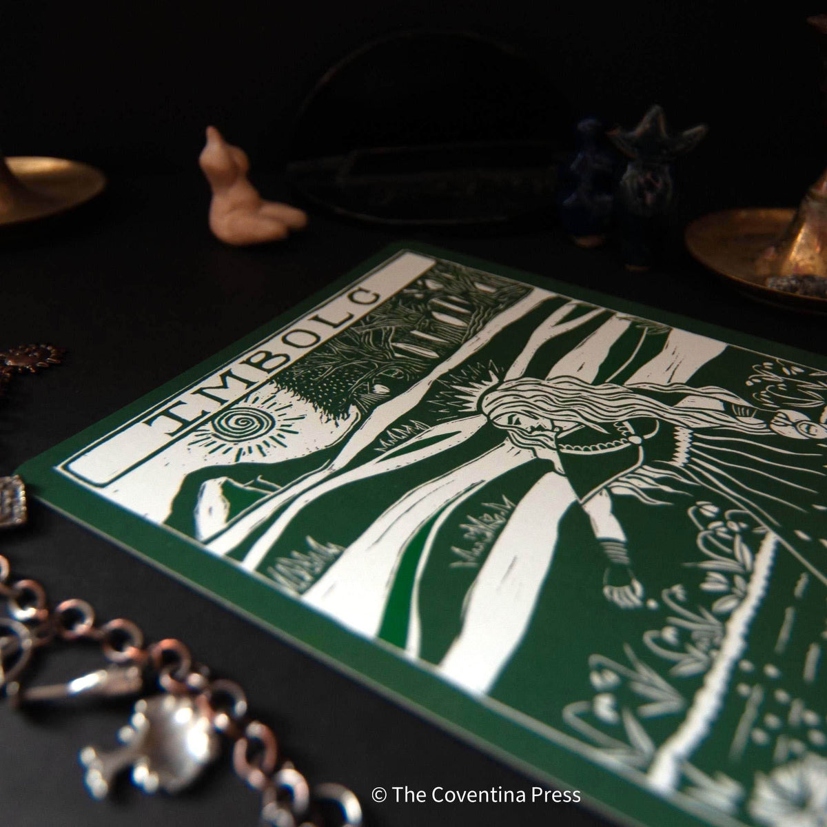 IMBOLC altar card in dark green and cream, featuring a bold linocut-style figure, sun motif and botanical details