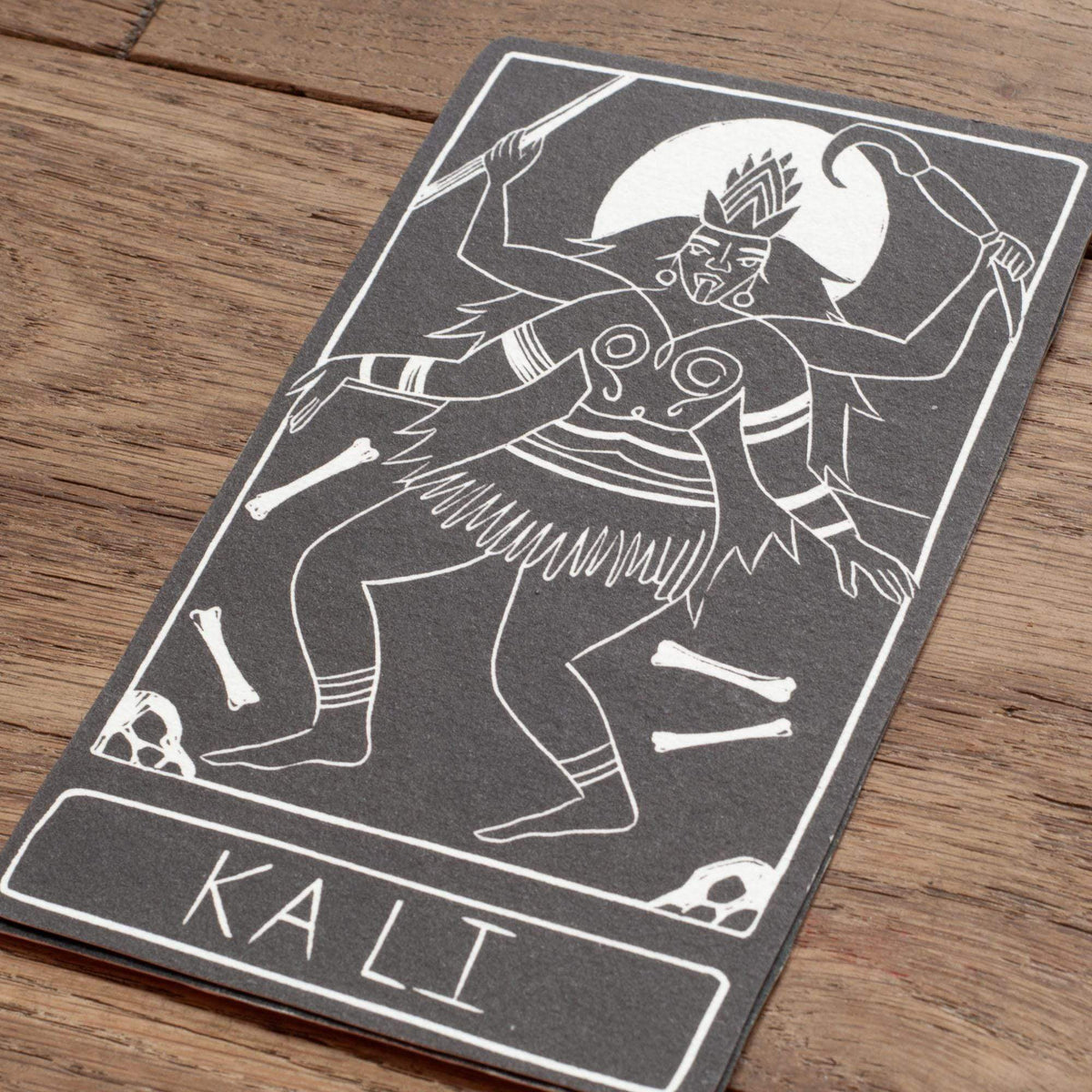 KALI ALTAR CARD in charcoal cotton rag card, featuring a white linocut of multi-armed Kali with skulls and bones