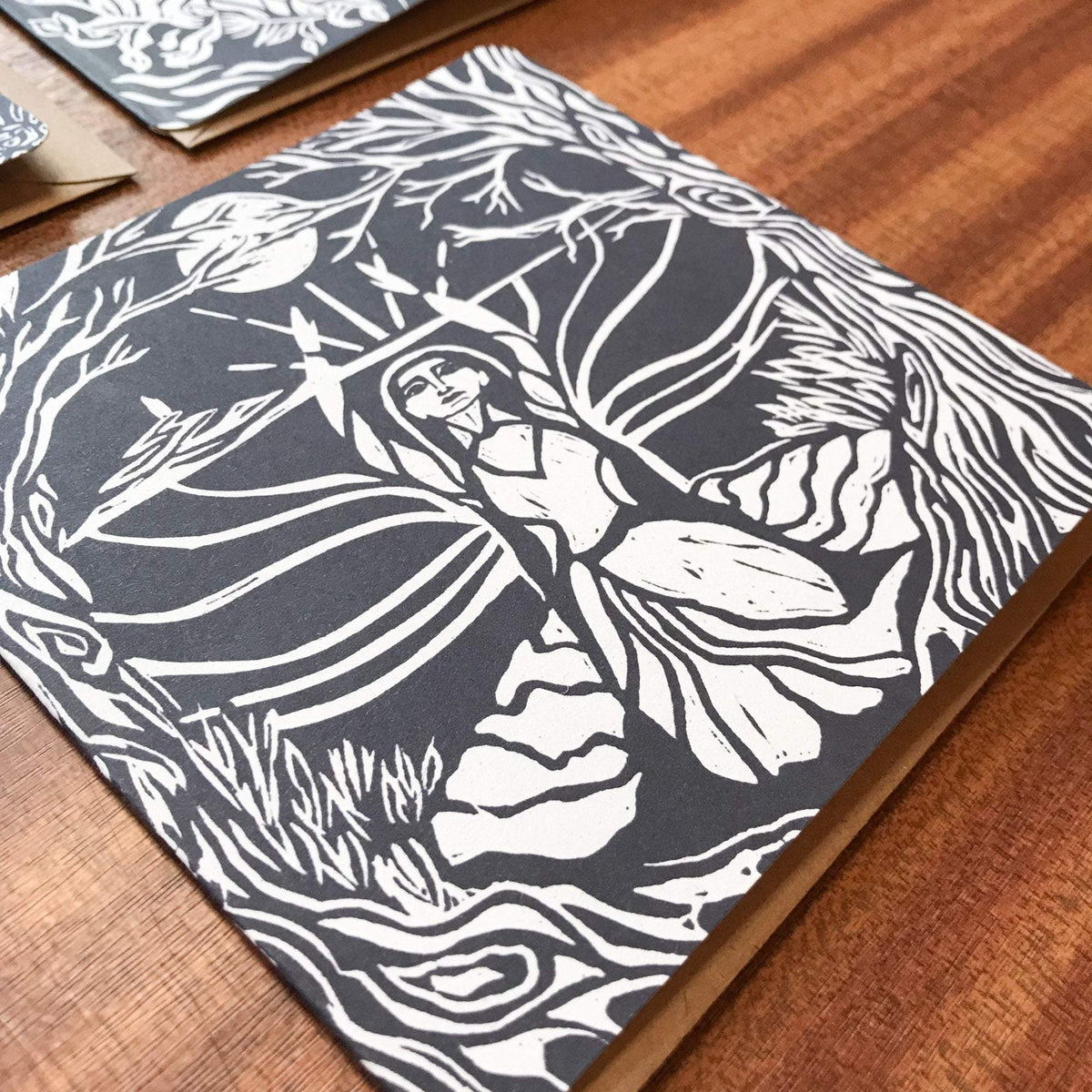 MORGANA LE FAY Greeting card in charcoal and cream, featuring a bold linocut of a woman among flowing branches