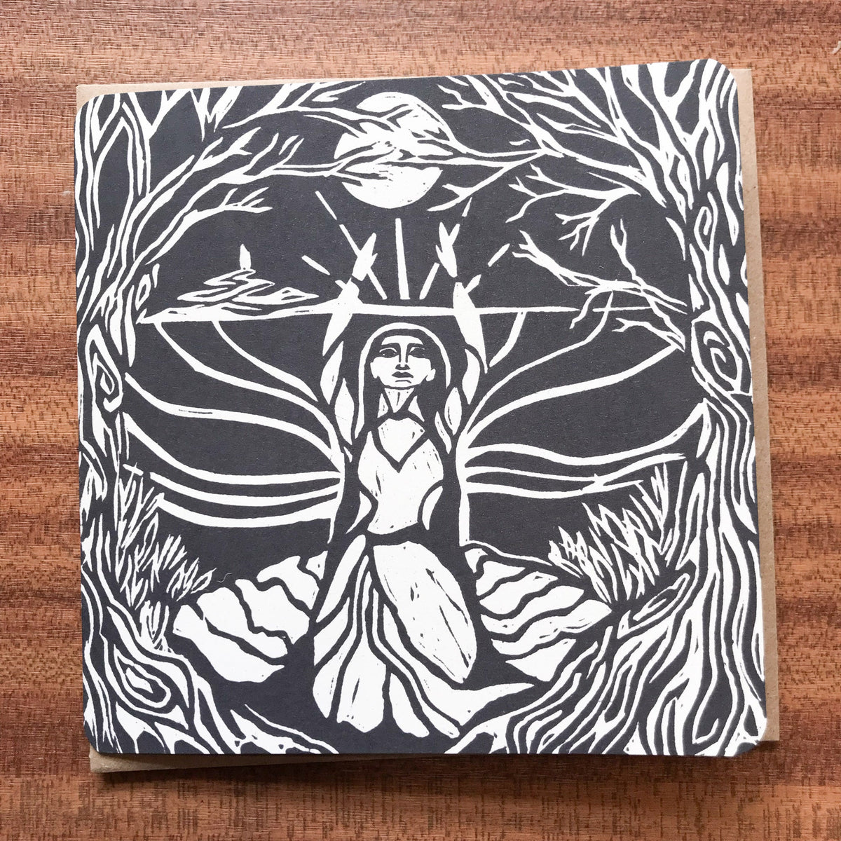 MORGANA LE FAY Greeting card in recycled cardstock, featuring a black-and-white linocut of a woman amid trees and flowing forms.