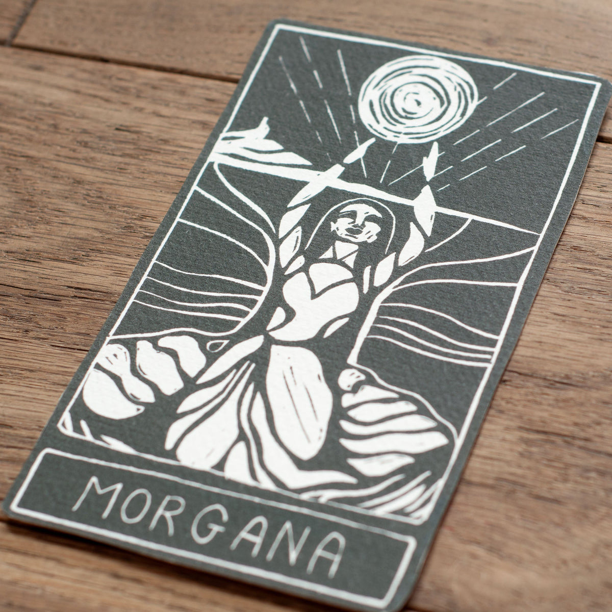 MORGANA ORACLE CARD in charcoal and white, featuring a handmade linocut of a goddess beneath a radiant sun