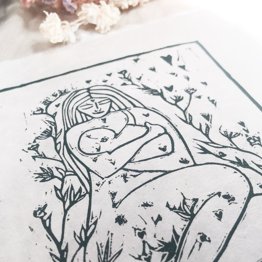 MOTHER AND BABE linocut print in dark green ink, showing a mother cradling her baby amid leafy branches