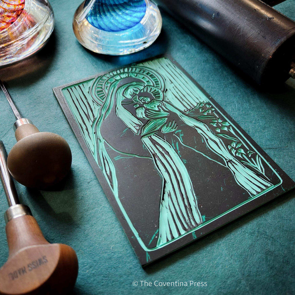 MOTHER MARY ALTAR CARD with a teal and black linocut-style image of Mary holding a child, framed by decorative lines
