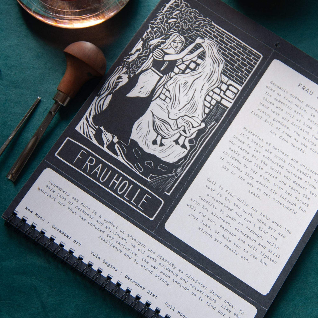 SACRED WITCH calendar with black-and-white linocut art of two figures, a Frau Holle title panel and spiral binding