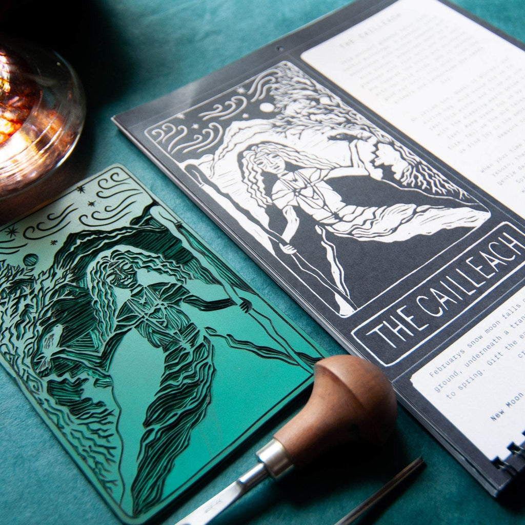 SACRED WITCH calendar with black-and-white goddess linocut artwork and a turquoise carved block featuring a witch