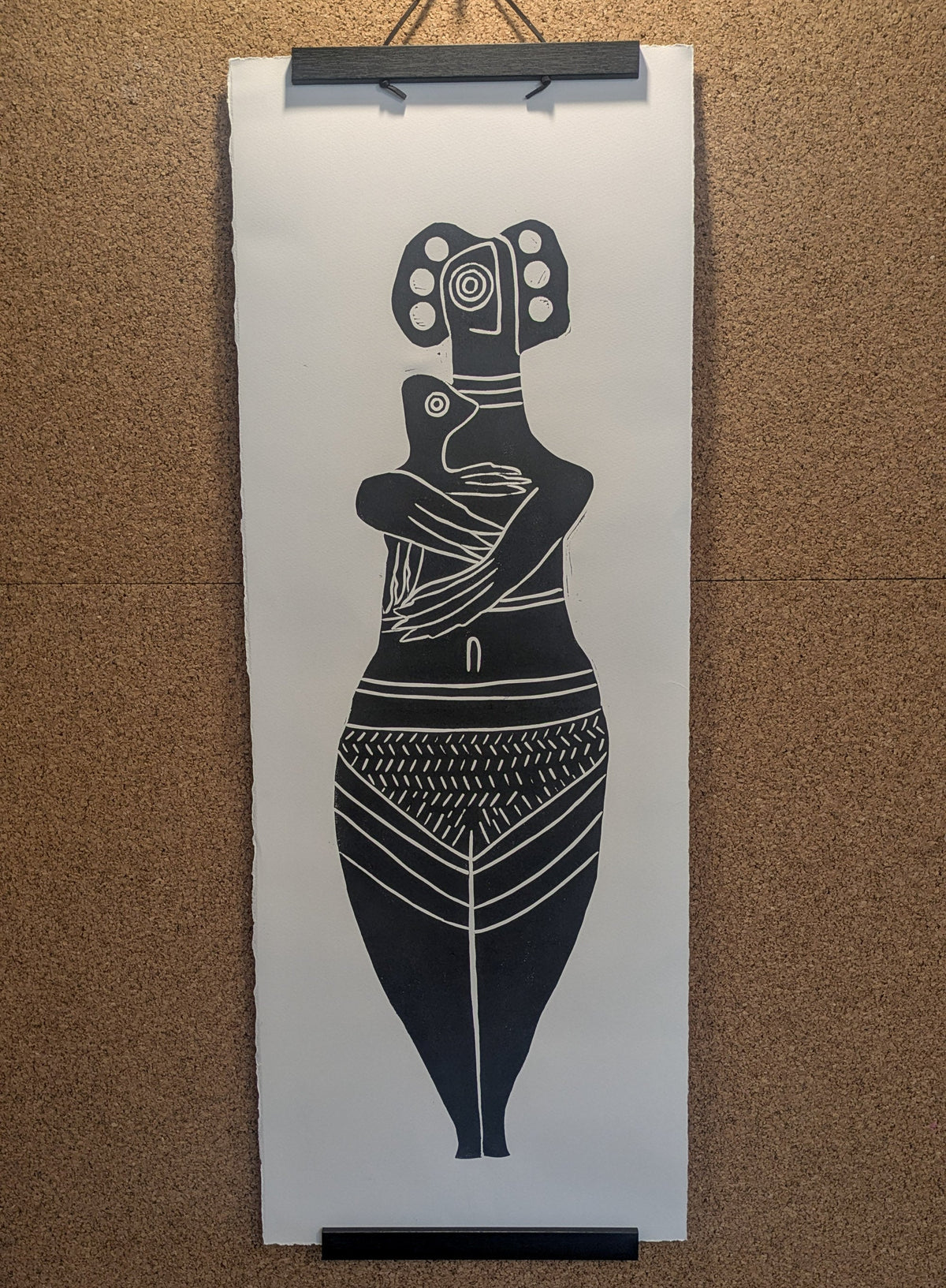THE BIRD HEADED MOTHER black linocut print of a stylized mother holding a bird-headed child, with geometric patterns