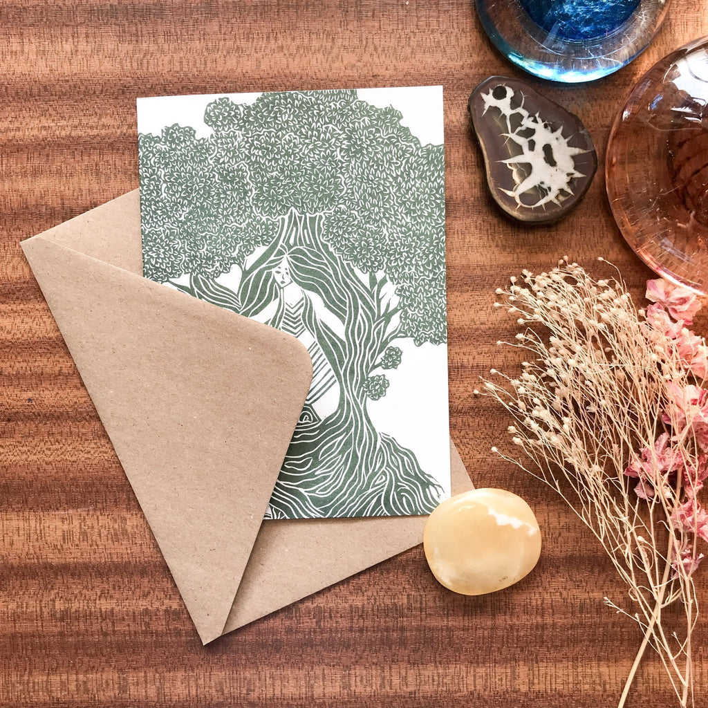 THE DRYAD greeting card in white with a detailed green linocut of a tree spirit, paired with a kraft envelope.