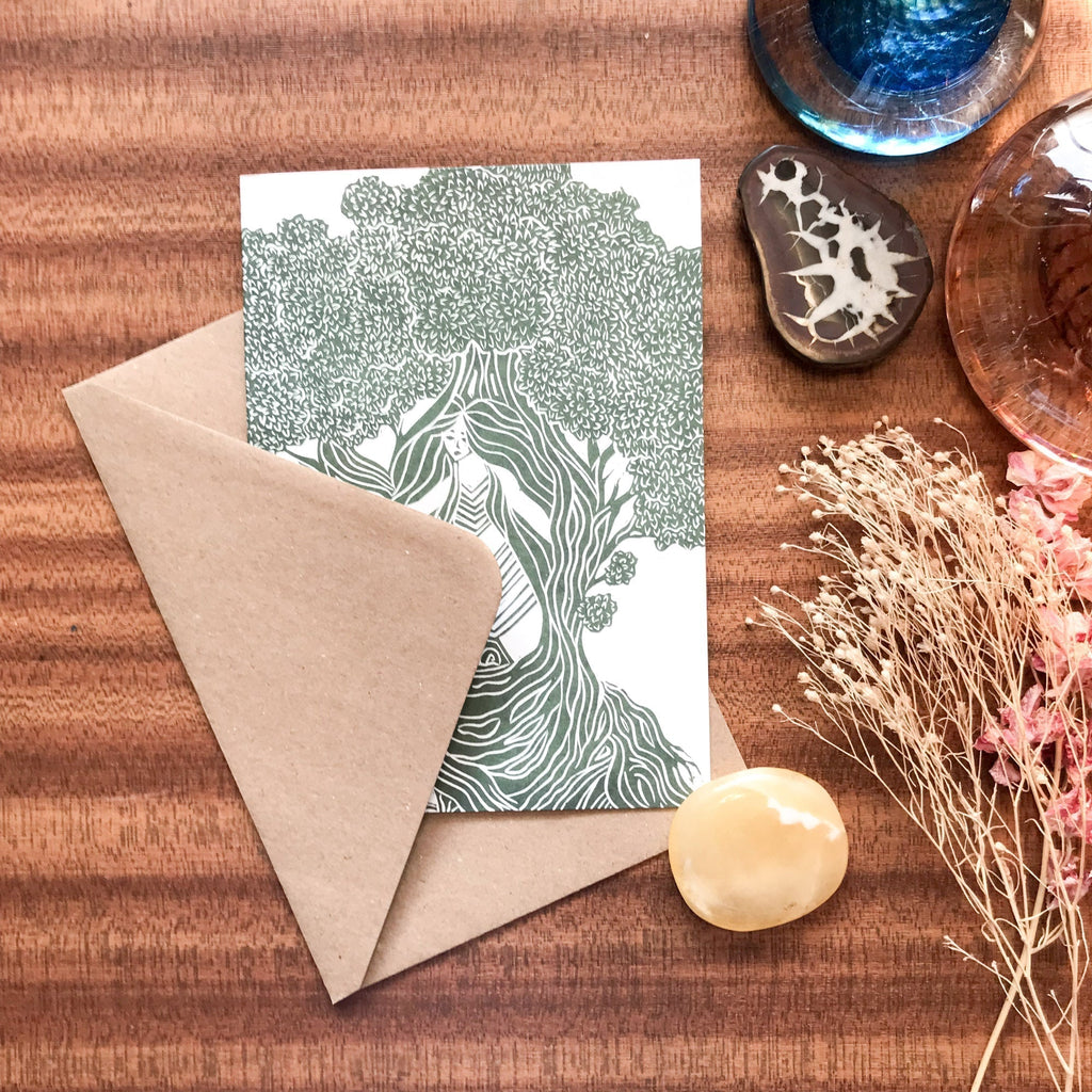THE DRYAD greeting card with a green-and-white linocut tree spirit design, paired with a kraft envelope.