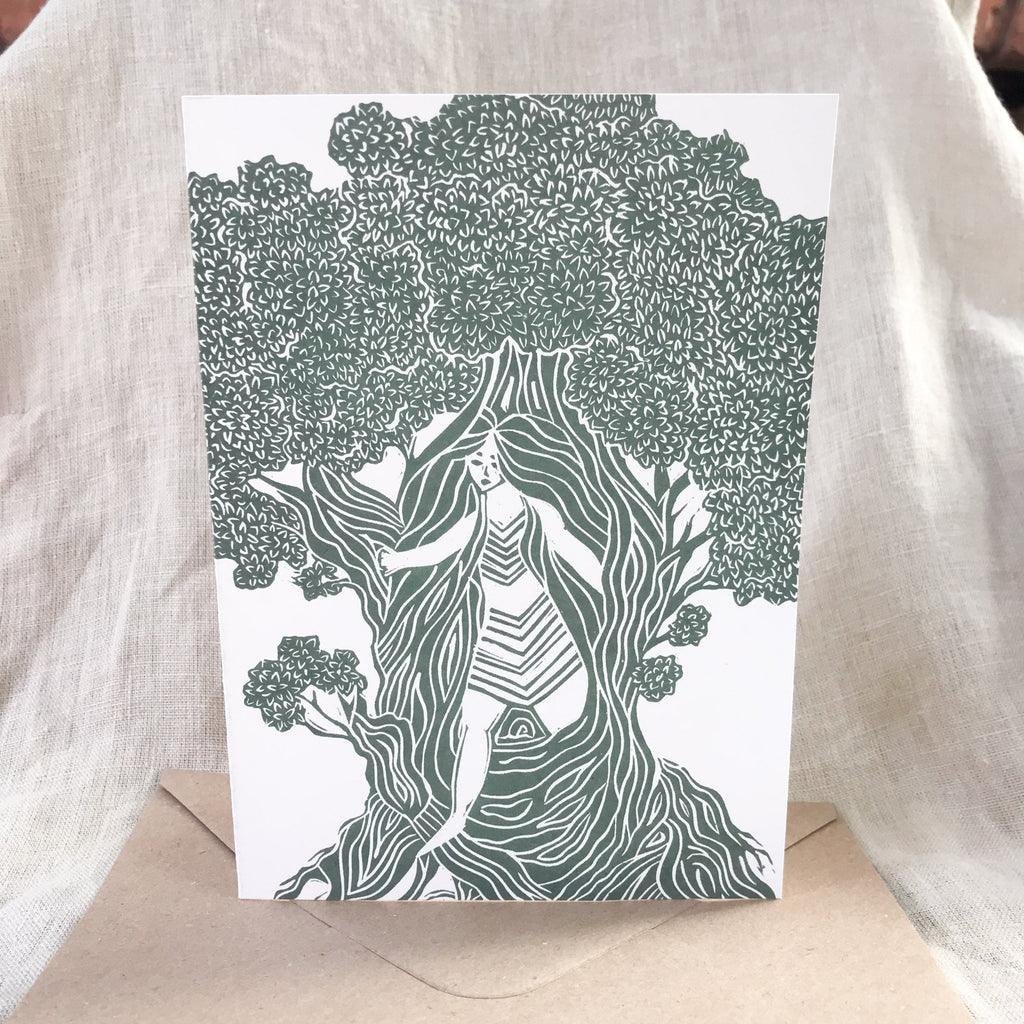 THE DRYAD greeting card with a dark green linocut of a woman emerging from a tree, on white card stock.