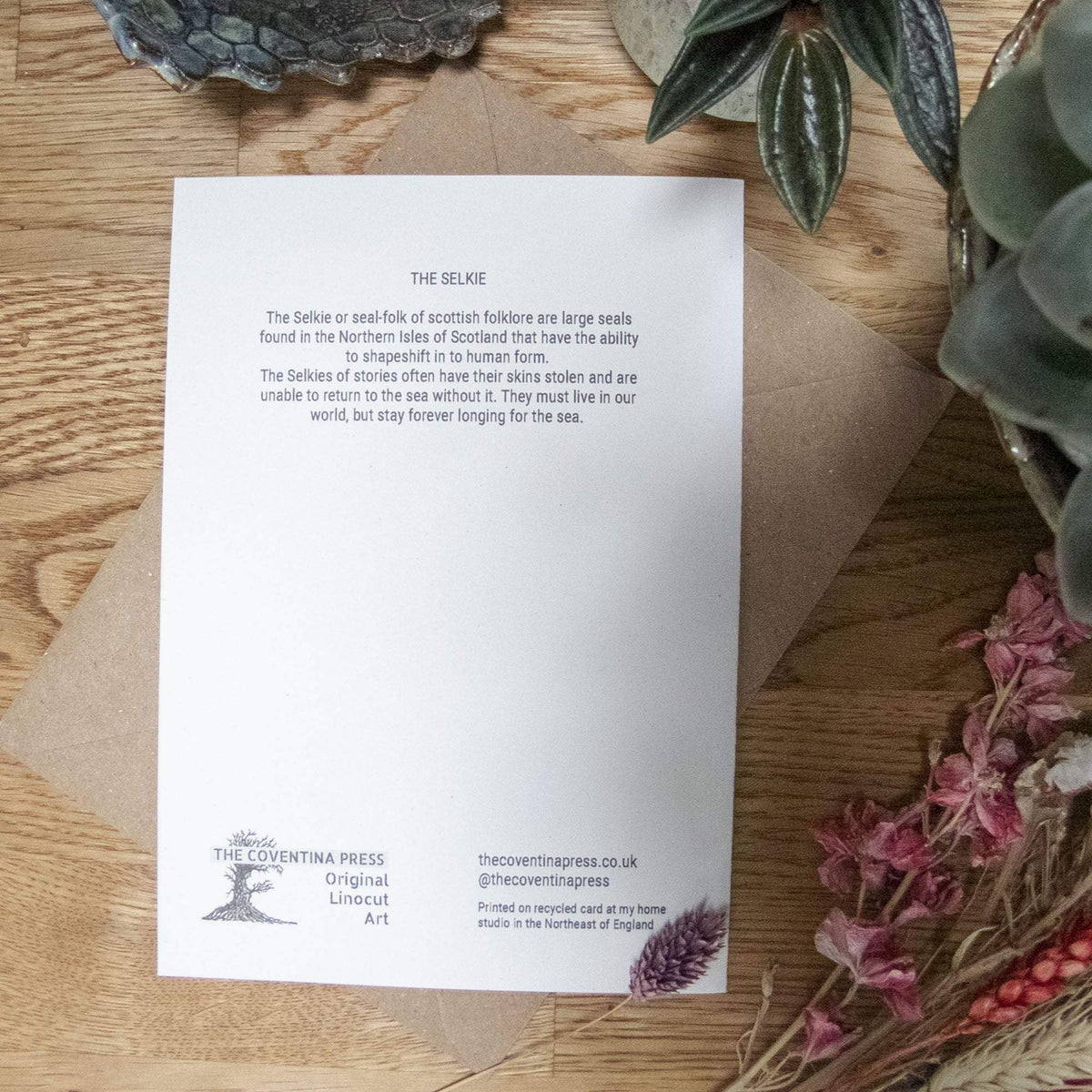 THE SELKIE Greeting card, white recycled cardstock with small black text and linocut seal artwork on the reverse.