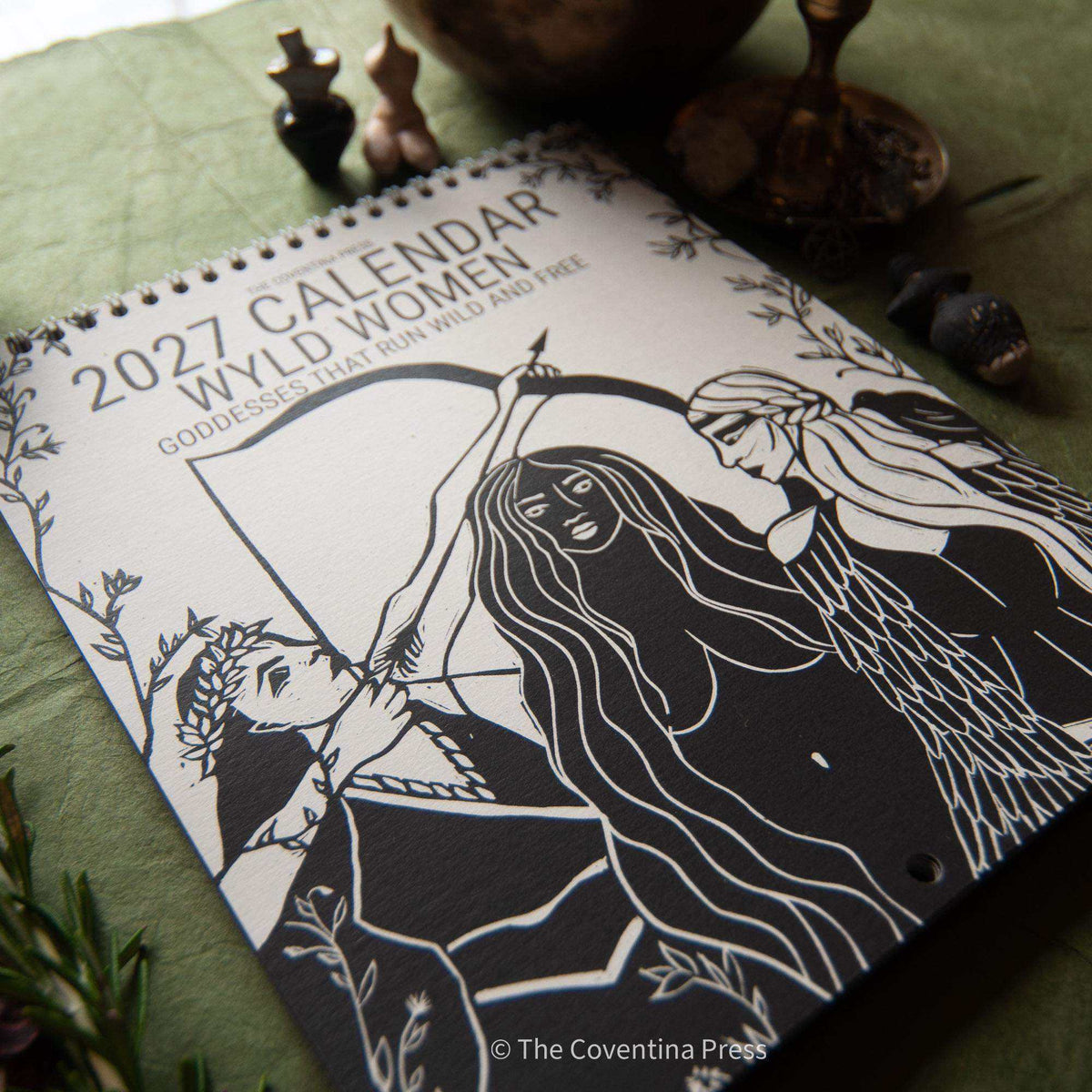 WILD WOMEN CALENDAR featuring a 2027 spiral-bound calendar with black linocut artwork of three goddesses
