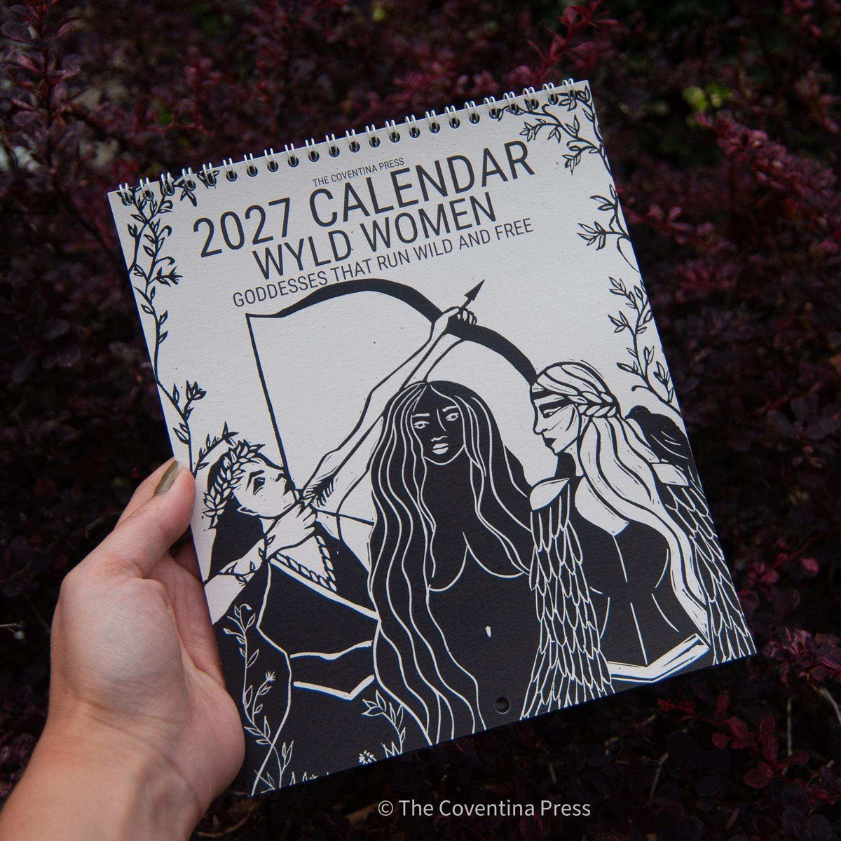 WILD WOMEN CALENDAR 2027 wall calendar with cream pages, black spiral binding and bold black goddess line art