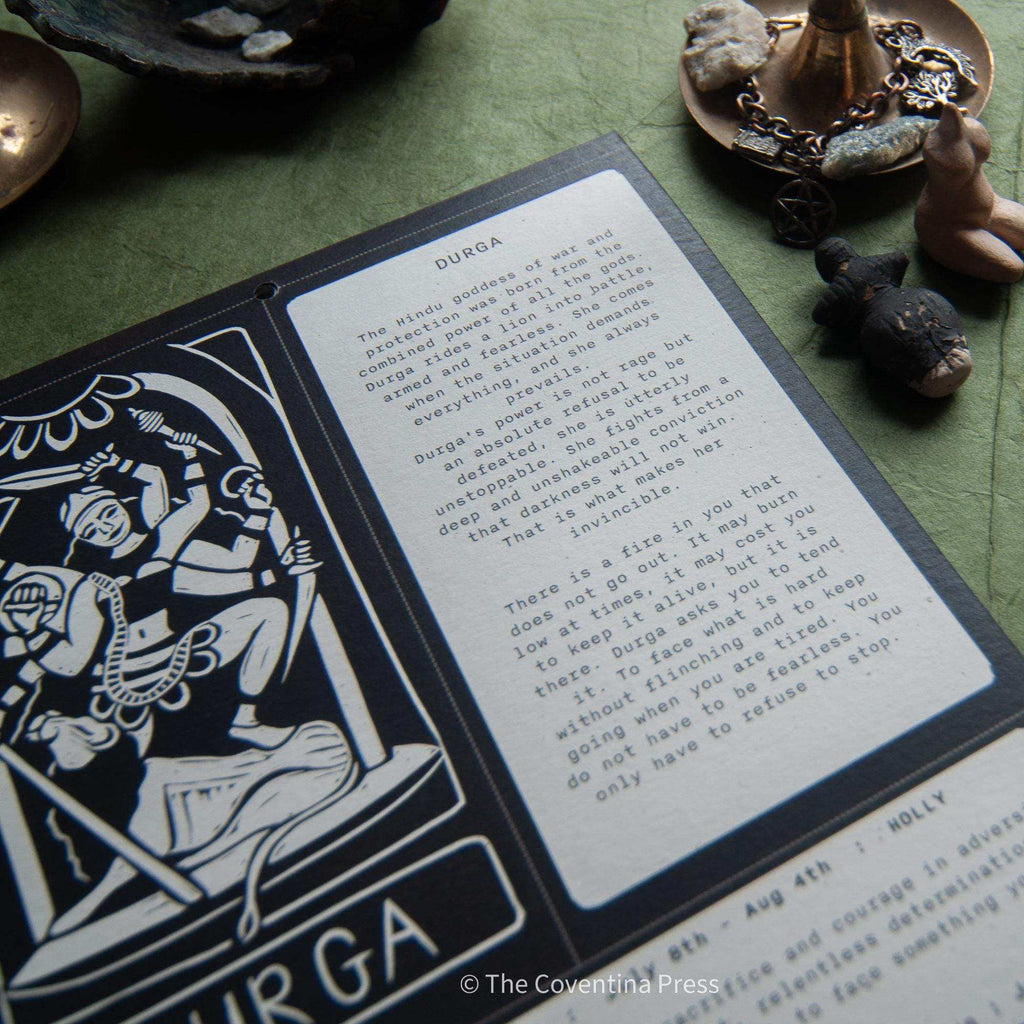 WILD WOMEN CALENDAR showing a black-and-white linocut goddess illustration beside a printed mythology and guidance page