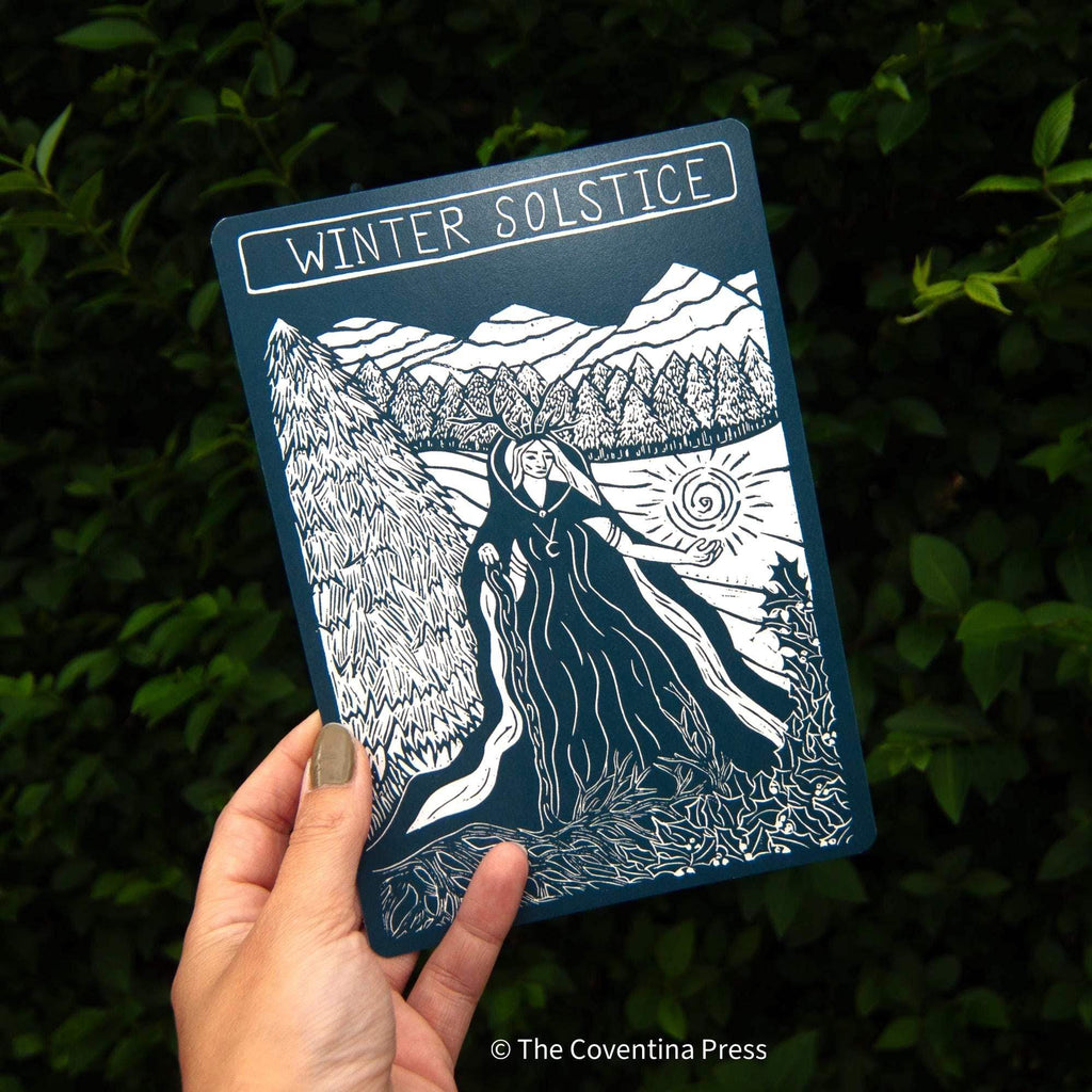 WINTER SOLSTICE altar card in deep blue with a white linocut of a cloaked figure, snowy mountains and trees